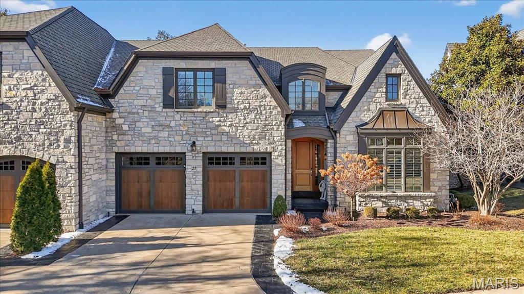 Luxury villa living at its finest in this stunning 1.5-story residence, thoughtfully designed with exceptional craftsmanship and upscale finishes throughout. Enter to find rich walnut hardwood floors spanning the main-level common areas and a light-filled formal dining room framed by expansive windows. The kitchen is truly spectacular, featuring granite countertops, custom cabinetry, a generous center island, and top-of-the-line appliances, including double ovens, two dishwashers, a gas cooktop, and a built-in refrigerator. An adjoining breakfast room and a private butler’s pantry provide both everyday comfort and effortless entertaining. The impressive great room showcases soaring 12-foot ceilings, a gas fireplace flanked by custom built-in bookcases, and sliding doors that open to the screened-in porch and deck with gas grill hook-up. The space flows seamlessly into a private office adorned with custom built-ins and exquisite millwork. The main-level primary suite offers a peaceful retreat with a tray ceiling, large bay window, and a luxurious en-suite bath complete with dual vanities, a soaking tub, walk-in shower, and a spacious walk-in closet with custom organizers. A laundry room and stylish powder room complete the main level. Upstairs, you’ll find a versatile loft space, two generously sized bedrooms, each with an en-suite full bath. The walk-out lower level is equally impressive, featuring a spacious family room with a gas fireplace, walk-behind wet bar, and sliding doors leading to a glass-encased patio. Additional lower-level highlights include a media room with built-in speakers, an exercise area, wine cellar, a bedroom, and a full bath. Additional features include 8-foot solid wood doors throughout, 8-room custom sound system, a custom-finished two-car garage, three-zoned HVAC, and the privacy of a gated community. Enjoy the perfect blend of luxury, comfort, and convenience with low-maintenance villa living.