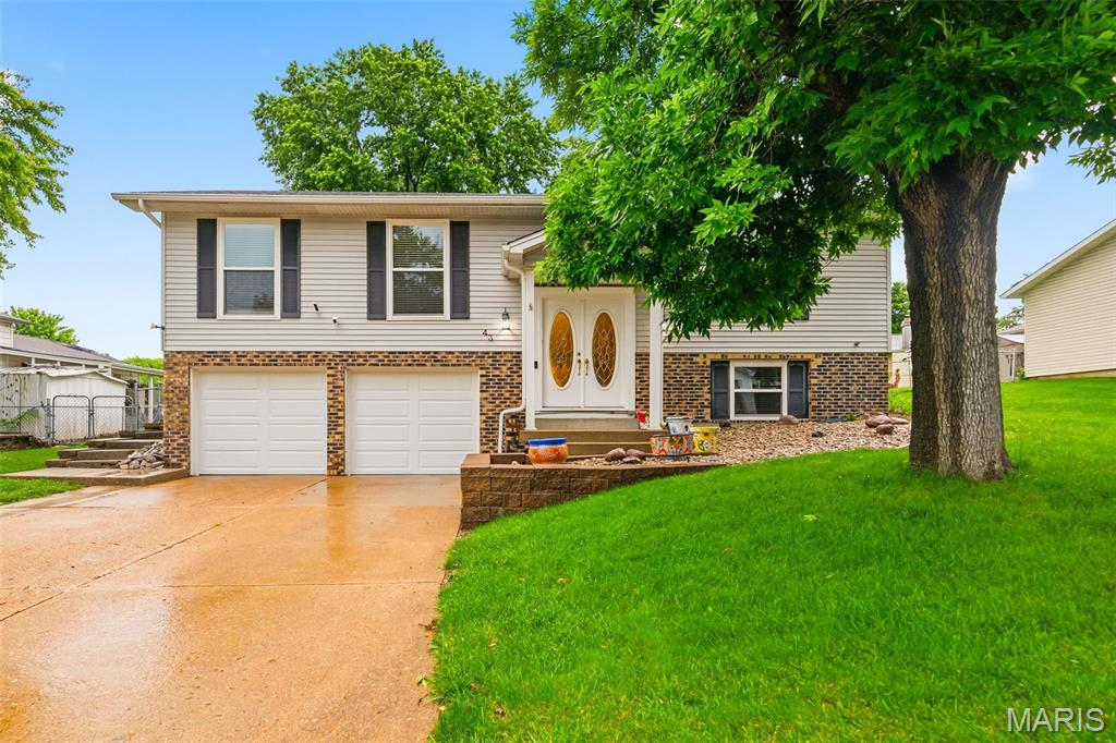 Beautifully updated split-level home in desirable St. Peters offering 3 bedrooms, 2 bathrooms, multiple living spaces, and incredible indoor/outdoor entertaining areas! Vaulted ceilings soar through the main living room, kitchen, and dining area creating an open and airy feel. LVP flooring runs throughout much of the main level. A truly move-in ready home!
The gourmet kitchen is loaded with upgrades including granite countertops, tile backsplash, under cabinet lighting, stainless steel appliances with 5-burner gas range, Ruvati workstation sink, pull-out drawers, and custom silverware organizer. Just off the kitchen is a spacious second family room featuring recessed lighting, mini split system, cozy wood burning fireplace, and slider door leading to the backyard patio and deck.
The primary suite includes a private ensuite bathroom with shower, while two additional bedrooms share an updated full hall bath. The lookout lower level offers additional living space with a second fireplace or potential 4th bedroom conversion. The adjacent bonus room could easily serve as a large walk-in closet, home office, or exercise area.
Step outside to enjoy the fully fenced level backyard with mature trees, patio, deck, relaxing hot tub, and storage shed for additional lawn equipment, tools, or outdoor storage. It’s the perfect outdoor space to unwind or entertain guests. Additional updates include all double-hung windows and insulated garage doors (2024), new gutters with leaf guards (2025), and new carpet and baseboards in all 3 bedrooms plus new LVP and baseboards in the living room, and replaced window sills (2026). Smart home features include Nest thermostat, Ring doorbell and security camera, plus MyQ remote garage access. Convenient location close to shopping, restaurants, parks, and highways in highly rated Fort Zumwalt (East) School District schools! Schedule your private showing today!