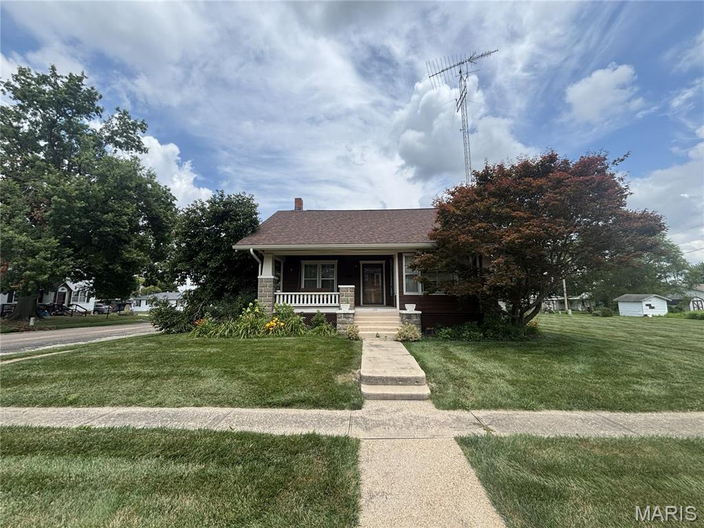 Character-rich craftsman on a beautiful .33-acre lot in Vandalia! Built in 1938, this 2-bedroom, 2-bath home has been well-maintained and is full of the original details that are so hard to find today.

Step onto the inviting front porch — complete with a porch swing, perfect for slow mornings and evening sunsets — and into a home where craftsmanship truly shows. Crown molding runs throughout, and the hardwood floors (including striking parquet sections) add warmth and character you won't find in newer construction. The living room centers around a wood-burning fireplace flanked by custom built-in chests, with elegant built-in China cabinets adding even more charm and function. The kitchen features custom cabinetry, offering both storage and style.

The home offers 2,111 adjusted square feet (2,630 total living space) of comfortable single-story living, with a walk-up upper level offering great potential for future expansion (currently unfinished/uninsulated) and an unfinished basement for storage or a workshop.

Outside, enjoy a back patio for entertaining, plus a detached two-car garage — all set on a generous corner-feel lot with room to spread out.
Homes with this much original character rarely come up for sale. Schedule your showing today!
