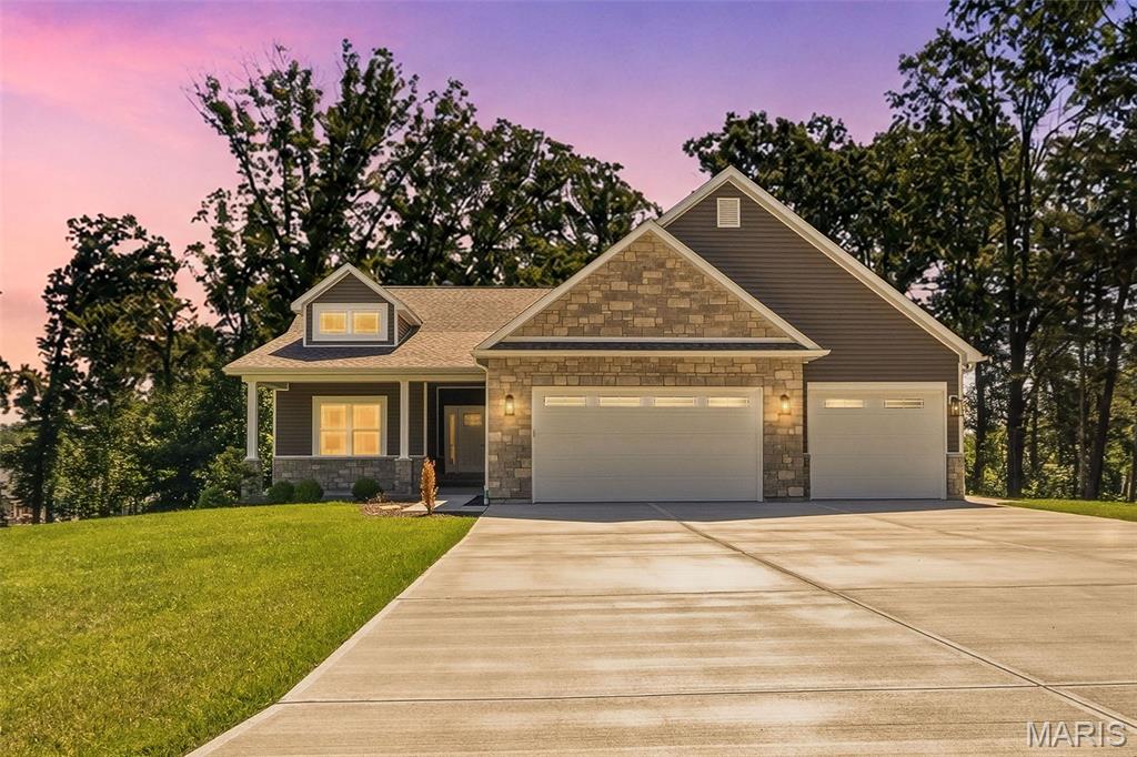 Just Minutes from Wentzville. This beautiful walk-out ranch home looks out over a 1.27 ac. lot with the privacy that comes when you back to woods! The home boasts Stone Veneer on the front w/ low maintenance vinyl siding, Enclosed Soffits & Fascia, a covered Front Porch, 3 Car Garage w/Wall Mount Garage Dr Openers (Lift Masters!), Insulated Garage Drs & Service Dr to the Side yard. Inside you will find almost 1,800 sq ft, 3 Bedrooms, 2 Full Baths with a 1/2 Bath, Vaulted & 9 Ft Ceilings w/Crown Molding, Can Lights, Wood Burning Fireplace w/blower, Stone Surround & Raised Hearth, Ceiling Fans, Upgraded Luxury Vinyl Plank Flooring, White Panel Drs & Trim, Main Floor Laundry Rm w/ lots of Cabinets. The Kitchen has Custom Cabinets w/ Hardware, Soft Close doors & drawers. There is a Center Island w/ Granite Counter Tops! There is also a Walk-In Pantry & Stainless Appliances! The Master Bedroom Suite is beautifully upgraded w/ a tray ceiling, can lights, a ceiling fan and a large walk-In closet!  The Master Bath has everything you need! Double sinks, Granite Counter Tops & walk-in shower! So many upgrades! Upgraded Insulation Package, Walkout L/L Offers 9 Ft Pour, Rough-In Full Bath, Sump Pit & Patio and a sodded yard w/ a Sprinkler System! This home is less than a year old and MOVE-IN READY!