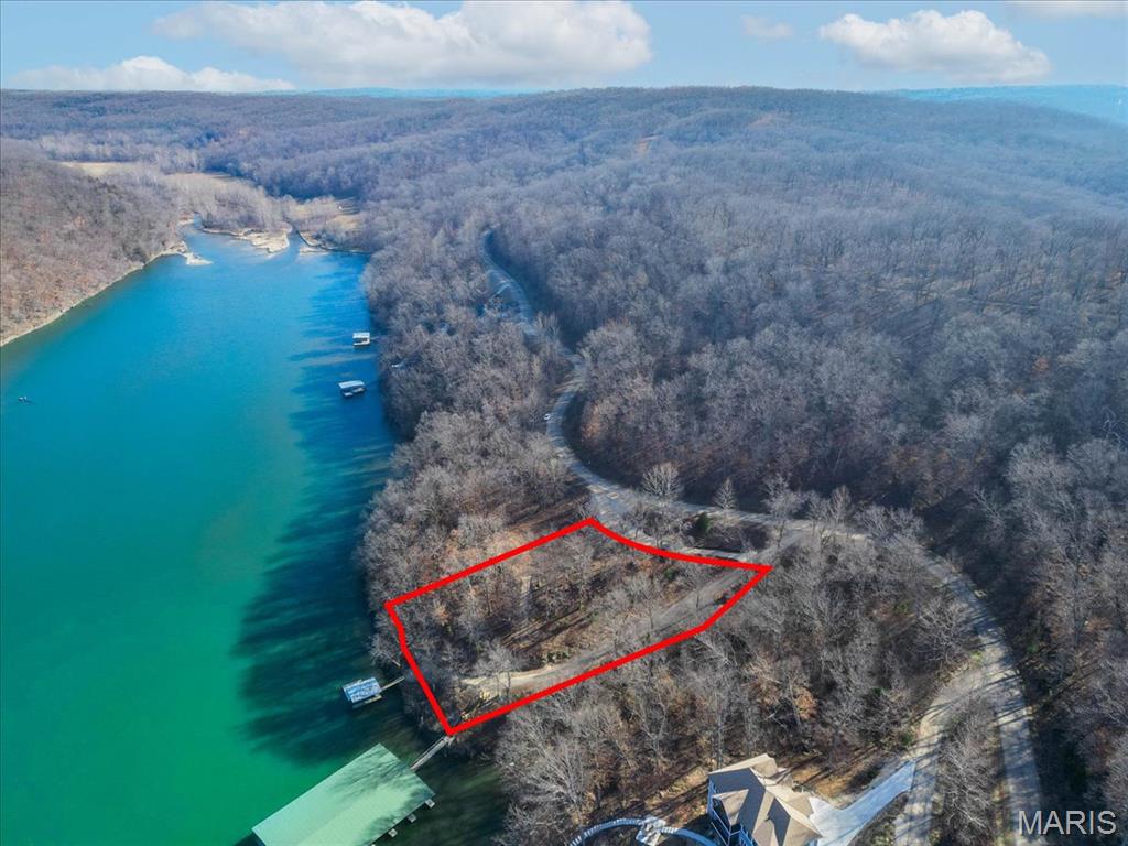 Prime 1.3-Acre Lakefront Canvas: Build Your Dream at Eagle Bay! Seize the rare opportunity to own a premier 1.3-acre lakefront lot in the prestigious Eagle Bay subdivision of Gravois Mills. This exceptional property offers 226 feet of pristine shoreline on the tranquil waters of the 55MM, providing the perfect balance of serene privacy and convenient access to local waterfront dining and city amenities. Already professionally cleared and primed for construction, this lot is a true "ready-to-build" gem waiting for your custom architectural vision. The groundwork has been laid for immediate enjoyment; the property is already equipped with a sturdy wooden dock featuring a 10x24 boat slip. Enhancing its incredible value, electric/sewer/water/fiber connections are already available on-site, significantly streamlining your building process. Whether you envision a sprawling multi-generational estate or a sophisticated modern retreat, the expansive footprint and gentle topography offer endless possibilities. Take the plunge and secure your slice of paradise in one of the lake's most sought-after communities. Schedule your private tour today and start living the lifestyle you deserve!