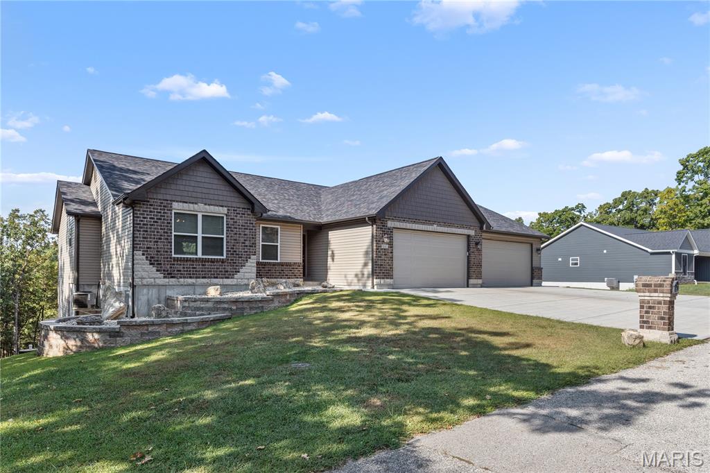 Lakes, white sand beach, golf and pickleball! This must-see 3-bedroom, 2-full bath residence is nestled on a large 2 1/2 lots (surveyed at .640 acres). The property features a 9ft HUGE basement with twin 50-gallon water heaters, and two walk-outs—one of which is a 6ft door for oversized access. Outside, you can enjoy a hot tub overlooking the forest and two covered decks - your own peaceful escape in nature. 

A standout feature is the finished, heated 4-car oversized garage, driveway space for 8 Cars!  Garage includes two 220-volt heaters, a 220V outlet for a welder or compressor, a mop sink, man door, windows and water line hookups. This space is perfectly suited for use as a main entertainment area or workshop.

Located within a gorgeous gated golf and lake community, residents have access to incredible amenities including four separate lakes for skiing, tubing, boating, fishing, swimming, sand volleyball, picnic areas,  as well as a white sand beach, pavilion, and campgrounds. Golf course amenities: golfing, salt water pool, pickleball, restaurant with sports bar and so much more!  Come experience the beauty, privacy, and charm-make this nature-filled retreat your own!