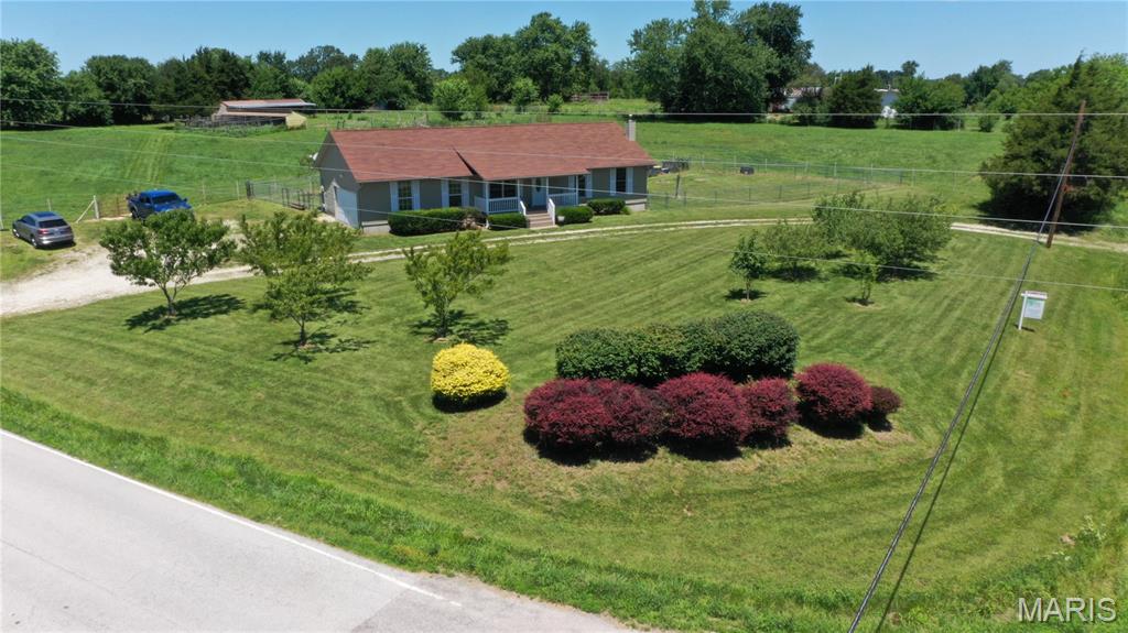 Enjoy Unincorporated Wright City living in this ranch home w/room for horses, dogs, chickens. Convenient location minutes from general store, this Mini Farm is ready for your critters! You will find 3 separate fenced pastures and a pony paddock, 3-stall shed row barn has tack/feed room. A lovely breeze flows through the lean-to area of barn nearly constantly and is open to a fenced off paddock so horses can come in and out as they please (no rushing home to bring them in during a quick down pour). Raised beds w/carrots, onion potatoes, herbs and also 6 apple trees, 4 peach trees, 1 cherry tree. Circle drive and 2 car garage w/workshop makes for plenty of parking options.
"Chicken coop" is an understatement and this building could also be used as dog kennel if preferred with new metal roof, 4 fenced runs with netting overhead, feed room and 4 separate nesting areas.
Private well and septic with fenced lagoon saves you so much room to use the acreage to it’s fullest.
Enjoy sitting on your covered front porch or patio under pergola out the back slider door with screen. 
Inside, the home features comfortable, carpet-free main-level living with durable Luxury Vinyl Plank (LVP) flooring throughout. The bright great room boasts a vaulted ceiling, newer windows, and a coat closet. The kitchen is outfitted with 42-inch staggered cabinetry, a sunny breakfast room, and stainless steel appliances that include refrigerator that stays. A main-floor mudroom adds great functionality with a slop sink and a stackable washer/dryer that stays, while the main level is rounded out by 3 bedrooms and 2 full baths with a linen closet.
The finished lower level adds fantastic bonus space, featuring a large recreation room with painted rough-cut cedar walls, a cozy wood-burning stove, a massive storage room, and a second laundry option. Built for ultimate peace of mind, the home is entirely electric and comes fully equipped with a whole-house backup generator and a top-tier water filtration system featuring a UV light, filter oxygenator, and water softener. This property is truly ready for you to move right in and start living the farm life!