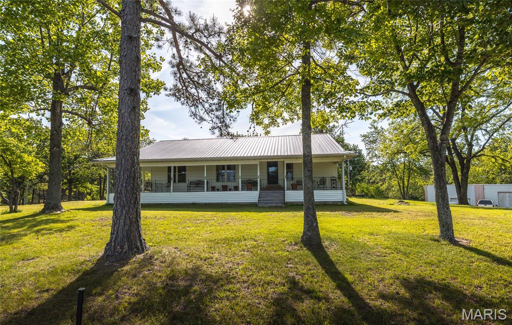 This property offers the kind of setup that's hard to find-a spacious country home with privacy, functionality, and direct access to some of the best outdoor recreation in the Ozarks. Located just minutes from the Current River and approximately 1 mile from Flat-Nasty Off-Road Park, this property would make an ideal full-time residence, weekend retreat, hunting cabin setup, or AirBnb investment. 
The home features a large-open concept layout with generous living space and oversized covered porches on both the front and back, creating plenty of room for entertaining and hosting. The setting is quiet and well-kept with mature shade trees and beautiful towering pines throughout the property. 
Outside, the property is loaded with usable improvements including quality fencing, a gated entrance, 5 ponds, a large shop with oversized bay, and a separate chicken barn/building. An additional utility hookup is already in place for an RV, camper, mobile home, or guest quarters. 
Whether you're looking for a forever home in the country or a property with strong short-term rental potential near the river and trail systems, this one offers the space, setup, and location to do it all.