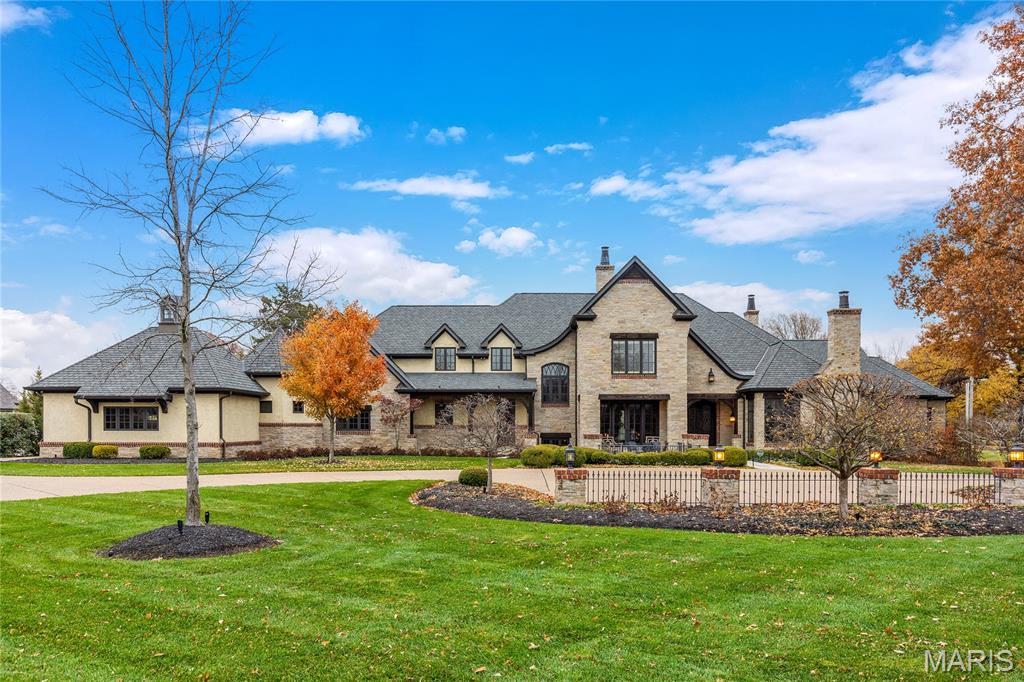A rich blend of brick, stone & stucco defines the rustic elegance & timeless architecture of this exquisite residence from St. Albans Construction Co. Custom trim work accents are featured throughout the interior that enjoys an abundance of natural light & striking visual cues. Impressive flagstone porch entrance with 9’ wrought iron double doors leads to foyer lined by diagonal hardwoods, library paneled dining room with 2-sided fireplace & French doors to terrace & vaulted study surrounded by natural wood paneling & bookcases. Timber beams & hardwood flooring set the tone for the stunning great room with floor-to-ceiling stone fireplace, 2-sty wine cellar & wet bar. The main living area unfolds into the state-of-the-art kitchen featuring quartzite countertops, glazed white cabinetry, commercial grade appliances, 10’ center island & dining table, auxiliary kitchen & hearth room highlighted by full-height fireplace. Primary bedroom suite with beamed cathedral ceiling & lavish bath with walk-through shower & jetted tub offers an appealing retreat. Oak staircase accesses 4 additional ensuite bedrooms, bonus room & 2nd floor laundry. Lower Level entertainment space includes recreation room, game room, family room with 3-sided fireplace, theater room & gathering bar plus workout room & full bath with steam shower. Situated on parklike 3-acre grounds with outdoor kitchen & living room, pool house with apartment, resort style pool flanked by 2 cabanas, garden house & 6 parking spaces. In addition, 5 geothermal HVAC systems function to significantly reduce utility bills.