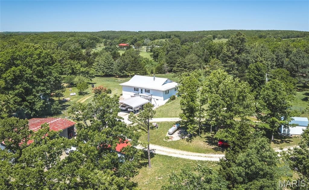 Welcome to Edgar Springs! Nestled on just under 13 picturesque acres, this charming farmhouse-style ranch is the perfect blend of peaceful country living and functional space. Offering 3 bedrooms, 2 bathrooms, and endless potential, this property is ideal for those dreaming of a hobby farm, family retreat, or simply room to spread out and enjoy the outdoors. Inside, you'll find a welcoming eat-in kitchen and a spacious living/dining room combination that opens onto the back deck — the perfect spot to unwind and take in serene country evenings. The primary suite offers additional space and comfort alongside two additional bedrooms and a shared full bath. Outside, the large detached garage/outbuilding and two additional sheds provide ample room for equipment, hobbies, animals, or storage needs. A full unfinished walk-out basement offers even more opportunity to create the space you've always envisioned. If you've been searching for quiet country charm with room to grow, this one is a must-see — schedule your private showing today! Oh, and if your electricity ever goes out...don't worry, seller just installed a new Generac Full Home Generator!