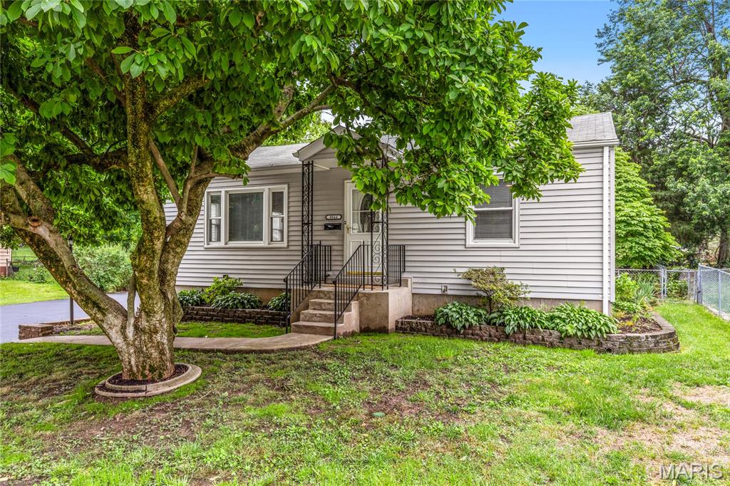 Tucked into the heart of St. Ann, this beautifully renovated ranch blends fresh modern updates, functional living spaces, and the kind of move-in-ready feel buyers are searching for. Surrounded by mature trees and filled with natural light, the home feels bright, welcoming, and updated from the moment you arrive. Inside, fresh paint and luxury vinyl plank flooring flow throughout the main living areas, creating a clean and cohesive feel. The spacious family room opens seamlessly to the updated kitchen featuring custom white cabinetry, quartz countertops, stainless steel appliances, black hardware and fixtures, a single basin sink, and an adjoining breakfast area perfect for casual dining or everyday living. Easy access to the covered deck creates effortless indoor-outdoor flow and expands the home’s entertaining space. Two comfortable main floor bedrooms offer ceiling fans, neutral finishes, and ample closet space, while the beautifully updated hall bath features modern fixtures, an updated vanity, and custom tile surround. The finished lower level adds incredible flexibility with a large recreation area featuring recessed lighting, LVP flooring, painted exposed ceilings, and walk-up access to the backyard. An additional bonus room creates the perfect space for a home office, workout room, hobby space, or guest area. Outside, the covered wood deck overlooks the fenced backyard shaded by mature trees, creating the perfect setting for relaxing, entertaining, or enjoying quiet evenings outdoors. A detached two-car garage, vinyl siding and thoughtful updates throughout add comfort, functionality, and peace of mind. Conveniently located near parks, St. Ann Golf Course, shopping, dining, and major highways, this beautifully updated home offers the perfect blend of comfort, style, and everyday convenience. Don’t miss out!