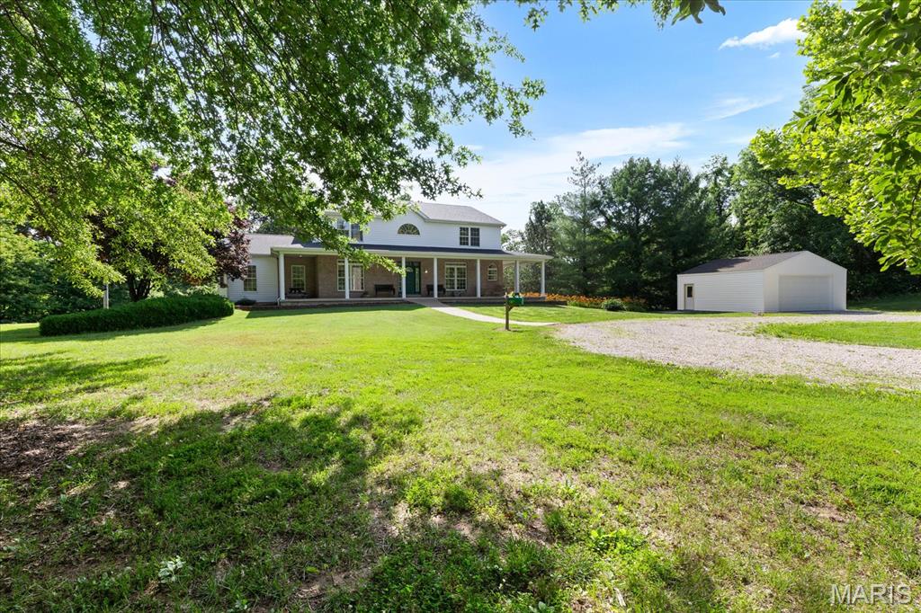 Custom 2-story estate offering over approx. 5,000 sq ft of finished living space on 3 private, park-like acres in Winfield. From the mature trees, circle driveway, and 700+ sq ft wrap-around covered front porch, this home delivers the privacy, space, and presence buyers look for in a true custom acreage property.

Inside, the grand 2-story foyer with ceramic tile and custom curved staircase sets the tone. The main level features 9 ft ceilings, wide 4.5 ft hallways, six-panel interior doors, Amish-built cabinetry throughout, built-in bookcases, and generous room sizes. The kitchen offers granite countertops, tile flooring, gas cooking, stainless appliances, recessed lighting, breakfast bar, and a walk-through pantry/laundry area with custom shelving. The formal dining room includes a coffered ceiling and recessed lighting, while the impressive 2-story great room features built-ins, a gas fireplace, and an open, inviting layout.

The main-level primary suite is a standout with a vaulted ceiling, crown molding, bay window, new carpet, private bath, and oversized 15’ x 9’ walk-in closet. The primary bath includes ceramic tile flooring, double-sink vanity, jetted tub, and separate shower. Upstairs offers three spacious bedrooms, including walk-in closets in two bedrooms, plus a loft/office with custom built-ins.

The finished walkout lower level adds major usable living space with 9 ft ceilings, ceramic tile flooring, a large recreation room, game room, office/bedroom, full bath, abundant storage, and a striking masonry gas fireplace with a 20 ft hearth. This level is ideal for entertaining, guests, hobbies, work-from-home space, or extended living.
Outdoor living is just as impressive, with expansive back and side patios overlooking the peaceful acreage.
 
Additional highlights include a detached 26’ x 26’ garage, brand-new roof in June 2025, zoned HVAC, whole-house humidifier, double 50-gallon water heaters, gas utilities, 200-amp electrical service, attic fan, tiled drainage system, county water, septic system, and extensive closet/storage space throughout. A rare opportunity to own a spacious custom home on private acreage with quality craftsmanship, major updates, and room to spread out.