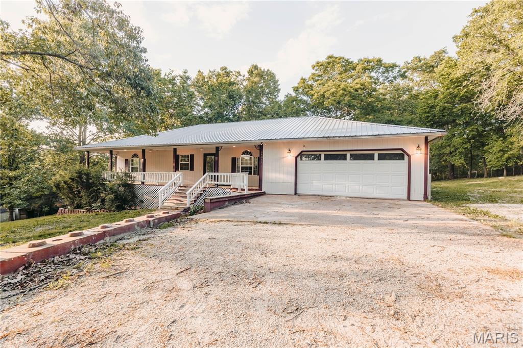 Fresh updates. Fresh opportunity! Many major updates have been completed, including a new metal roof in May 2026, professional painting, cleaning, surveyed in 2026, and additional improvements, making this spacious ranch-style home move-in ready. Conveniently located just over a mile from town with an easy commute to Ft. Leonard Wood, this property offers a peaceful setting with only three homes on the lane. Built in 1992 and well maintained, the home features a welcoming entry, spacious living area, and a cozy den or office with wood flooring. The kitchen and dining area offer wood floors, a breakfast bar, and functional flow for everyday living and entertaining. The primary suite includes new carpet, a walk-in closet, and private bath. A generously sized second bedroom also includes a walk-in closet, while the oversized hall bath features new flooring and ample space. The finished lower level provides two additional large bedrooms with walk-in closets plus a versatile bonus room with a window, ideal for an office, hobby space, or additional sleeping area. Outdoor living shines with a full-length covered front porch, expansive rear deck with covered and open sections, and a second covered deck overlooking a tree-filled backyard designed for relaxing and entertaining. Washer and Dryer to be included with the home.  If you are looking for space, comfort, and a peaceful setting with convenient access to town and Ft. Leonard Wood, this home deserves a look.