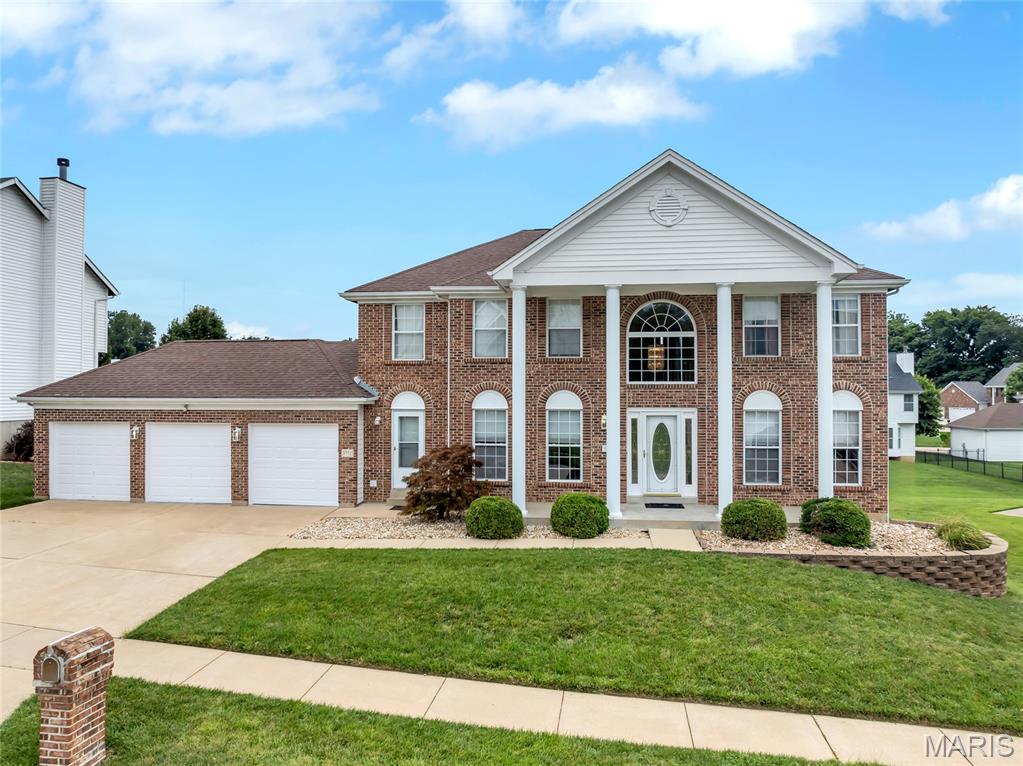 Welcome to a home where timeless elegance, generous living spaces, and thoughtful updates come together beautifully. From the moment you arrive, the stately brick veneer front, classic columns, three-car garage, and professionally landscaped yard create an impressive first impression.

Step inside the dramatic two-story entry foyer, where marble flooring, abundant natural light, and a striking butterfly staircase set the tone for the rest of the home. The marble flooring continues into the separate formal dining room, creating an elegant setting for dinner parties, celebrations, and holiday gatherings. A separate living room offers additional space for quiet conversation, reading, music, or a private sitting area.

Large windows throughout the home fill the rooms with natural light and enhance the open, welcoming atmosphere. The spacious main-level family room features a fireplace and flows comfortably into the kitchen, making it easy to stay connected while relaxing, cooking, or entertaining.

At the heart of the home is the remodeled eat-in kitchen, designed with both everyday convenience and entertaining in mind. Marble countertops, a center island with an electric cooktop, double ovens, and an abundance of cabinetry provide plenty of workspace and storage for anyone who enjoys cooking. The adjoining breakfast room offers a bright and comfortable place for casual meals, morning coffee, or conversation.

Just off the kitchen, the hearth room provides another inviting gathering space with its own fireplace. Use it as a cozy lounge, conversation area, reading retreat, or additional entertaining space. The nearby main-level laundry room adds convenience and helps keep daily routines organized.

Step outside onto the newer composite deck and enjoy coffee, outdoor dining, or peaceful evenings overlooking the beautifully landscaped backyard. The home is positioned on a desirable walkout lot, providing direct access from the finished lower level to the outdoor space.

Upstairs, four generously sized bedrooms provide comfortable and flexible accommodations. The oversized primary suite feels like a private retreat, complete with a separate sitting room that may be used as a reading area, home office, exercise space, or relaxation lounge. The ensuite bathroom features a separate shower, a soothing soaker tub, dual vanities, and a walk-in closet, creating a comfortable space to begin and end each day.

The fully finished walkout lower level expands the possibilities even further. This versatile area includes a kitchenette, additional eating space, a media room, a recreation area, a full bathroom, and a possible fifth bedroom, sleeping area, or office. Create a movie lounge, game room, guest retreat, workspace, hobby area, or additional entertaining space tailored to your needs. Abundant storage provides room for seasonal items and everyday organization.

Additional features include updated flooring throughout, zoned heating and cooling for enhanced comfort, a sprinkler system, multiple fireplaces, and furnishings included with the sale. With its open floor plan, flexible living areas, elegant finishes, spacious bedrooms, and exceptional indoor and outdoor entertaining spaces, this home is ready to complement a variety of lifestyles.

Schedule your private showing and experience everything this exceptional home has to offer.
