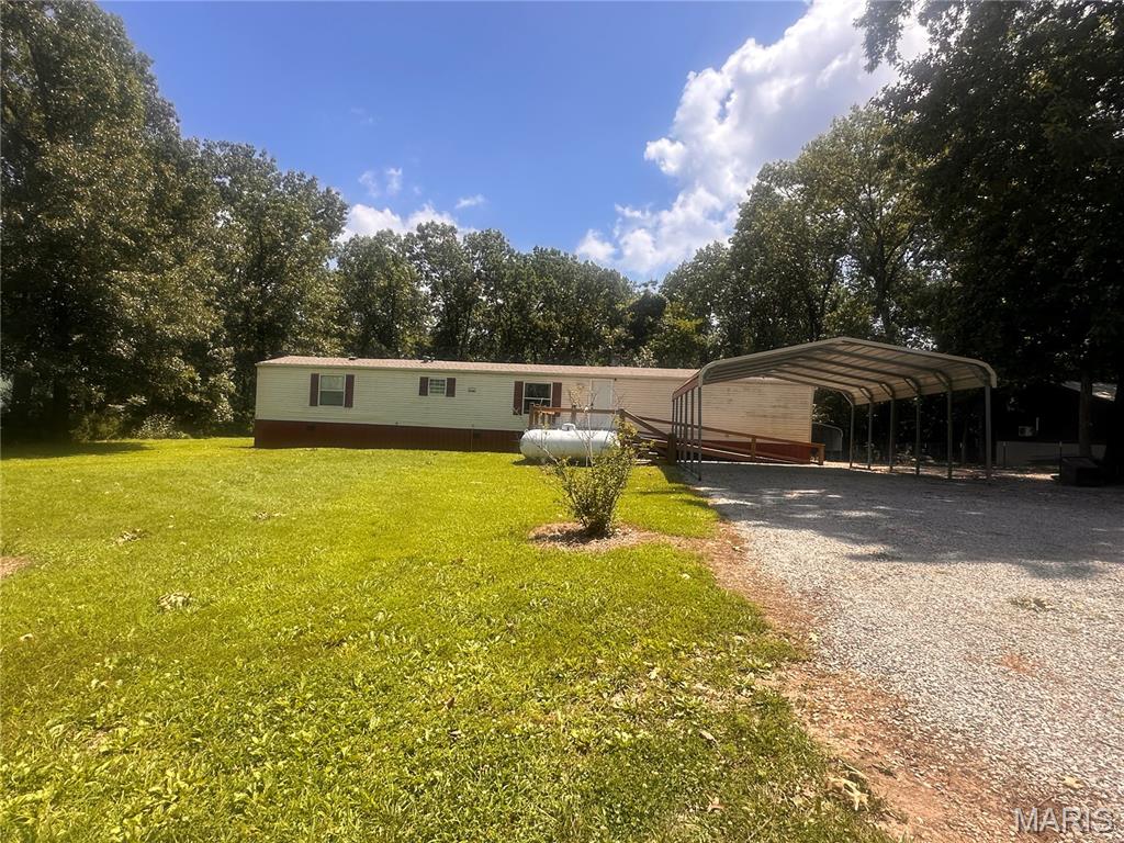 Escape to the peace and quiet of Truman Lake with this well-maintained 3-bedroom, 2-bath home located in the desirable Deer Run Subdivision. Situated on more than half an acre and backing to Corps of Engineers ground, this property offers exceptional privacy, beautiful wooded surroundings, and direct access to the natural beauty that makes this area so special.

Inside, you'll find an inviting open-concept living and dining area featuring updated laminate flooring throughout and a cozy gas fireplace, creating the perfect space for relaxing or entertaining. The spacious kitchen comes complete with a gas range, refrigerator, dishwasher, microwave, washer, and dryer, allowing you to move in and start enjoying your new home from day one.

Step outside onto the large covered deck overlooking the expansive backyard, where you'll have plenty of room for family gatherings, gardening, outdoor recreation, or simply enjoying the peaceful setting and abundant wildlife. A wheelchair-accessible ramp provides convenient access to the home.

The property is well-equipped for lake living with three covered carports offering ample space for vehicles, boats, and trailers, plus an RV hookup already installed for visiting family and friends. A storage building provides additional space for equipment, while the bonus cabin, already plumbed, offers endless possibilities as a future guest house, workshop, hobby space, or weekend retreat.

Located just minutes from Berry Bend Boat Ramp on Truman Lake, this property is ideal for fishing, boating, hunting, and enjoying the outdoors. Whether you're looking for a full-time residence, a retirement home, or the perfect weekend getaway, this property combines comfort, convenience, and outstanding recreational opportunities in one exceptional package. Properties offering this much outdoor space, covered parking, and direct access to nature are becoming increasingly difficult to find. Don't miss your opportunity to make this peaceful lake-area retreat your own.