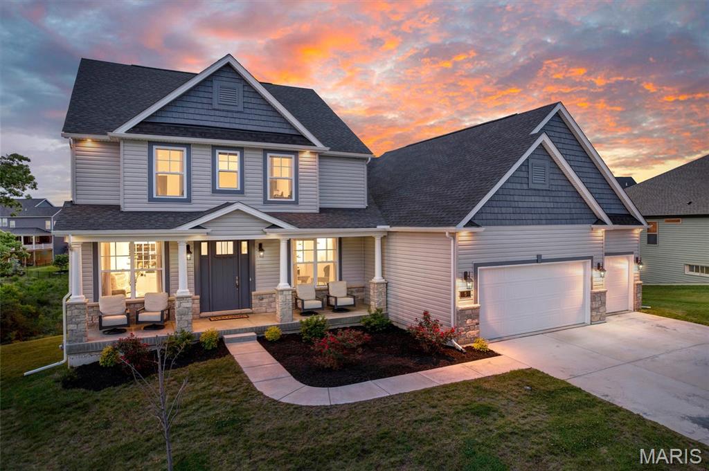 Set within one of O’Fallon’s more refined and established enclaves, this craftsman style Lombardo-built residence offers a level of finish and architectural presence that speaks directly to buyers who value craftsmanship, intention, and understated luxury. From the moment you arrive, the elevated exterior with upgraded stone detailing, shake accents, and 8-foot entry door establishes a tone that carries seamlessly throughout the home’s thoughtfully curated interior. Inside, a formal foyer with 9-foot ceilings planked by a formal dining room and office, opens to an 18-foot soaring great room with a wall of windows, nearly 4000 sq ft of living space, tailored trim work, and an open staircase, creating a sense of quiet sophistication while open sightlines and architectural overlooks enhance both scale and flow. The kitchen was designed not simply for function, but for gathering, featuring built-in appliances, sprawling quartz surfaces with seating for six, an oversized sink, upgraded soft-close cabinetry with dovetail construction, walk-in pantry, and a statement stone-arched cooktop wall that effortlessly supports entertaining on any scale. The great room centers around a direct-vent fireplace finished with stone delivering both warmth and visual permanence. The main level is anchored by a true primary suite retreat, thoughtfully positioned for privacy and ease of living. Tray ceiling detail, two walk-in closets, and a spa-inspired bath appointed with an adult-height double vanity, separate tub and shower, & a private powder room create a space that feels intentional and restorative. A refined front office flexes seamlessly into a playroom or a den, while a well-placed half bath, spacious laundry room, and functional family entry room support everyday living without compromising aesthetic appeal. One of our favorite features is the sunroom that's wrapped with windows offers a secondary living space ideal for relaxation or study. Three sizable bedrooms are located on the upper level and all are attached with full bathrooms, each with walk-in closets offering comfort and privacy for family members or guests. Additional considerations such as a walkout lot, a full bath rough-in for the lower level, upgraded lighting selections, archways throughout, and full-house window grilles further reinforce the home’s commitment to quality at every turn. All of this is situated within the highly regarded Wentzville School District, in a community known for its balance of privacy, prestige, and proximity to modern conveniences. Homes of this caliber, in settings such as this, represent not simply a residence, but a lifestyle intentionally designed and rarely duplicated.