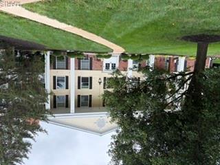 Enjoy comfort and convenience in this beautifully updated 2-bedroom 2-bath condo.  Wood-style flooring (2026) flows thru most of the home.  The living room boasts cozy gas fireplace with marble surround.  Step out on your private deck and unwind while enjoying tranquil view of peaceful, wooded area.  The dining room is perfect for those special occasions. An updated in in kitchen features white cabinets, hard surface counters and stainless-steel appliances.  The den flowing from the living room is a perfect sport for office or private retreat . Main bedroom includes an ensuite updated bath with double sinks and a large walk in closet.  2nd bedroom has a walk in closet.  Hall bath has tub/shower and double vanities.  With convenient in-home laundry, garage and modern updates, this space combines comfort, style and practicality.  Walk to park, shopping and restaurants.