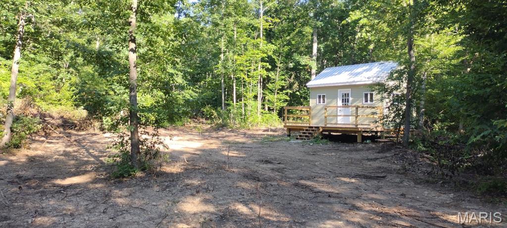 A new cabin tucked into a valley flowing with spring water. Secluded and serene! Make this your getaway base camp for Ozarks exploration, fun and relaxation. Or make it your forever homesite and live out your days in peaceful seclusion. The gravel road leading from the state road is a recorded legal easement road. You can hunt, camp, get around on your ATV or SXS. Just a few miles from Black River, Johnson Shut Ins, shopping and dining in the historic Arcadia Valley, visiting Elephant Rocks State Park and much more. Wild game is plentiful ... deer, turkey, small game ... it's all here. Or just sit in a lawn chair and unwind. 
There aren't many properties out there with this level of seclusion but with easy access. And two small spring streams converge on this property. 
Make it your relaxing getaway, or build it out as a escape if it all hits the fan some day. It has many features that a prepper would desire -- surrounded by hills while tucked into a valley, a source of continuous water, far off the beaten path. 
The seller has built a nice 12X16 cabin complete with a 8X16 deck. The hard part is done. Finish it out with the own preferences. And he's already wired it for electricity ... a generator or solar for now, but you could connect to the grid if you so desired.