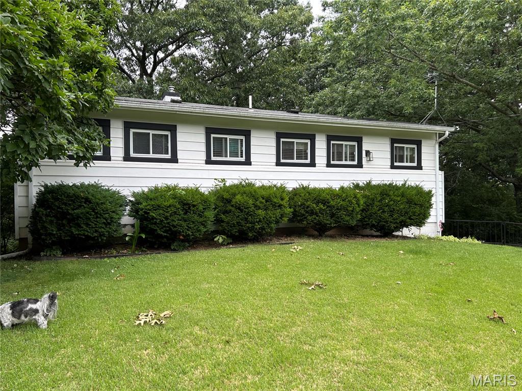 Come see this well designed house on 3/4 acre lot with woods offering an inviting living experience.  The Living Room has vaulted ceiling with woodburning fireplace with built in bookcases on each side.  The 2 bedrooms and 1 full bath provide ample space and flexibility.  Stunning real wood floors also!  The exterior is well maintained with a spacious yard backing to mature trees and lush landscaping.  Enjoy the large deck to entertain and enjoy the sounds of nature.  Partially finished full walk-out basement does have a 3rd bedroom if needed.  Parking for everyone!