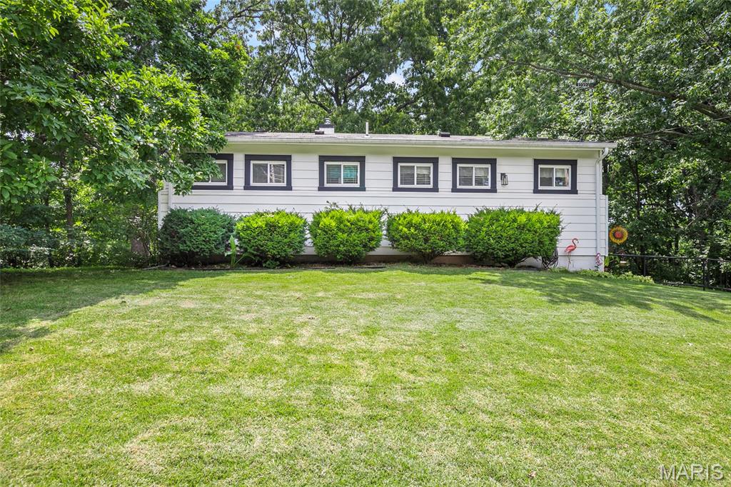 Come see this well designed house on 3/4 acre lot with woods offering an inviting living experience.  The Living Room has vaulted ceiling with woodburning fireplace with built in bookcases on each side.  The 2 bedrooms and 1 full bath provide ample space and flexibility.  Stunning real wood floors also!  The exterior is well maintained with a spacious yard backing to mature trees and lush landscaping.  Enjoy the large deck to entertain and enjoy the sounds of nature.  Partially finished full walk-out basement does have a 3rd bedroom if needed.  Parking for everyone!