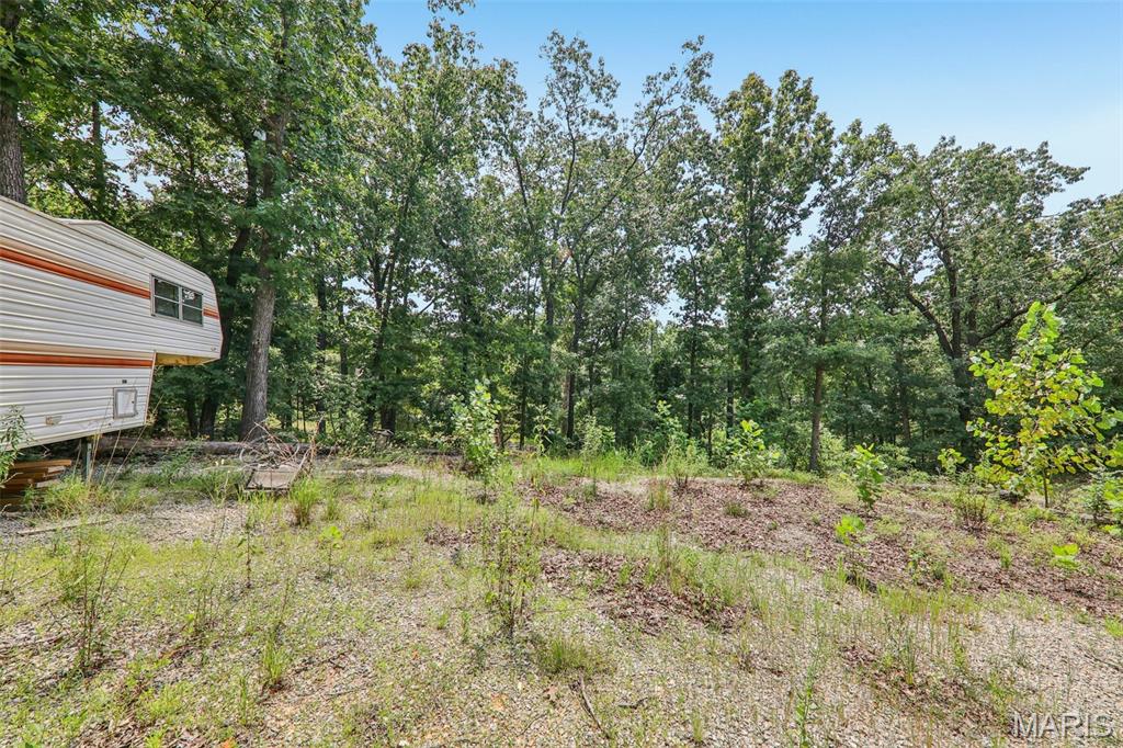 Welcome to Lot 25 in the beautiful Goose Creek lake community! This spacious lot offers access to several lakes with an impressive 400-acre main lake, perfect for boating, water skiing, and lakeside fun. Residents also enjoy a sandy beach, community swimming pool, and several smaller lakes and fishing ponds with maps for crappie beds ranging from 5 to 13 acres—ideal for quiet mornings with a rod and reel. There are multiple boat docks and a quiet time on the water in the evening around 8pm. Children can enjoy the playground, swimming pool, a swimming section on the lake with buoys and a dock to jump off of. Located about an hour from St. Louis, this community offers a peaceful retreat with year-round recreation and a welcoming atmosphere. Don't miss your chance to be part of this sought-after lake lifestyle! Camper on lot is included in the sale.