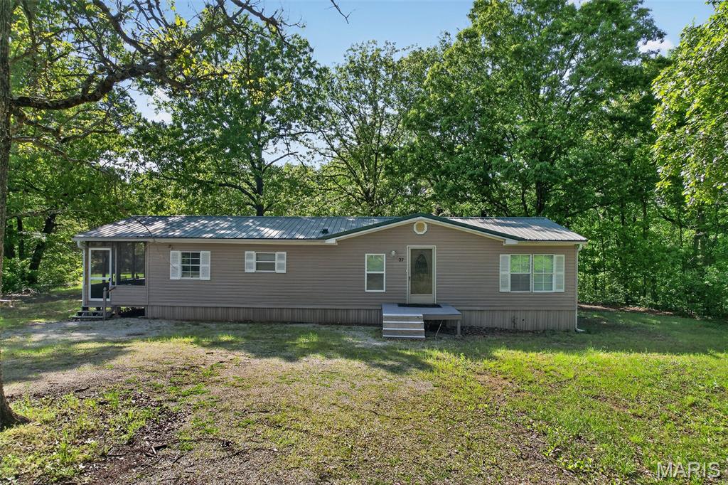 Tucked away on 15.21 private acres, this charming 3-bedroom, 2-bath manufactured home offers the perfect blend of comfort and seclusion. With 1,352 square feet, the home features a spacious open floor plan and a desirable split-bedroom layout, providing both functionality and privacy. The kitchen is equipped with newer stainless steel appliances, making it both stylish and practical for everyday living. Step outside to enjoy the peaceful surroundings from the beautifully screened-in sunporch, perfectly positioned to overlook a serene open space—ideal for relaxing mornings or quiet evenings. The property also includes a 30x30 shop with electric and concrete floors, offering excellent space for hobbies, storage, or a workshop. For added peace of mind, the home is equipped with a Generac generator, ensuring comfort and reliability during power outages. Whether you’re looking for a quiet retreat or room to spread out and enjoy the outdoors, this property has it all!