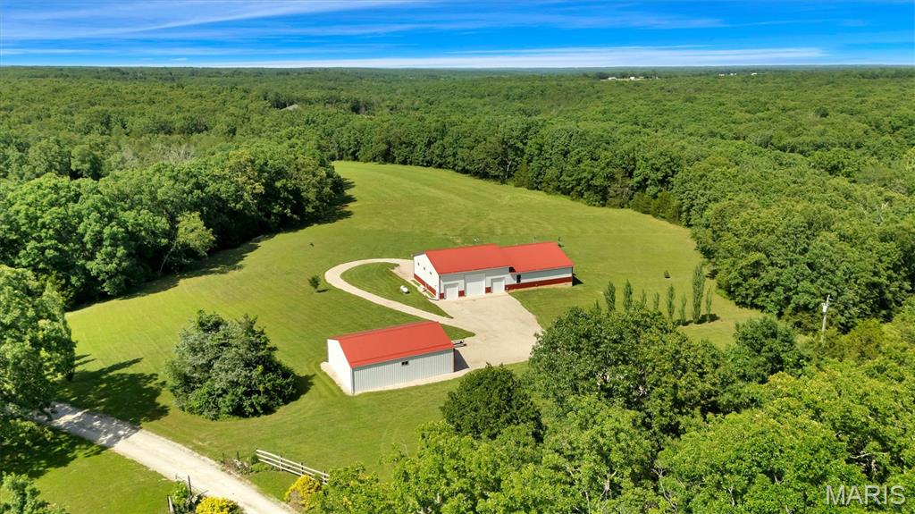 WOW!  Modern country living with unmatched shop space on 7+ private acres.

Welcome to this thoughtfully designed 2-bedroom, 2-bath home with a dedicated office that easily lives as a 3rd bedroom, paired with extraordinary, climate-controlled shop space—together offering just under 3,000 sq ft of finished versatility. Set beyond a thick treeline that wraps a sunlit meadow, this property blends quiet privacy with a prime location.

Inside the residence, warm craftsmanship meets modern comfort:

Tongue-and-groove vaulted ceilings and rich wood details create an inviting, airy living space.
Cozy up by the wood stove or flip on the sleek electric fireplace—ambience either way.
A chef-friendly kitchen features solid-surface counters, stainless steel appliances, and excellent storage.
Seamless indoor-outdoor flow to a covered, wrap-around porch with gorgeous meadow views off the kitchen and living room—perfect for morning coffee, sunset dinners, and year-round entertaining.
Two full baths and a flexible office/third-bedroom option support a range of living needs.
The ultimate finished Shop space doubles your possibilities:

Approximately half the total square footage is fully finished, insulated, heated and cooled shop.
Sealed concrete floors, finished storage cabinets, and a dedicated bar area elevate work and play.
Three garage bays, including one with 14’ pass-through doors—bring in RVs, boats, project cars, or large equipment with ease.
Need even more room to build, store, and create?

A separate 40' x 30' shop is fully insulated, with electric, overhead lighting, concrete floors, and a sturdy workbench—ideal for a small business, hobbyist, or wrenching.
Outdoor advantages that matter:

Just over 7 gorgeous acres of open meadow ringed by mature trees for natural beauty and seclusion.
A 30-amp RV hookup for visiting guests or your own getaway rig.
Quiet, private setting with convenient access to town and amenities.
This is not just a home—it’s a lifestyle compound where craftsmanship, comfort, and capability come together.


Behind the scenes, the home is incredibly well-built, featuring a fully encapsulated crawl space with a sump pump and backup pump for ultimate moisture control and peace of mind.

Whether you’re seeking a serene retreat, a high-functioning workspace, or an entertainer’s haven, this property delivers—beautifully.
