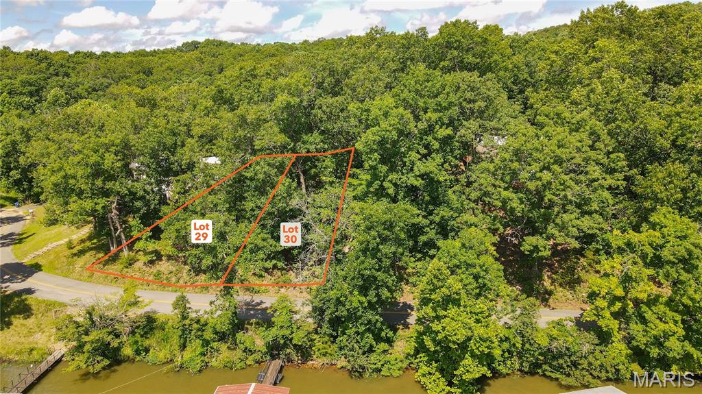 AUCTION LISTING - List price is not indicative of Seller’s final reserve amount.  This property is part of an online bidding event.  This sale will be executed with a no-contingency contract provided by brokerage representing the Seller. See MLS Supplement Document for complete details. Here is the perfect opportunity to build your dream home or lake getaway on the peaceful side of the Lake of the Ozarks. These attractive building lots offer the ideal combination of privacy, convenience, and excellent lake access. With blacktop roads leading all the way to the property, you'll enjoy easy year-round access without the hassle of gravel roads. Located directly across the road is the community lakefront, where you'll have the opportunity to install your own dock in a well-protected cove featuring good water depth throughout the summer pool season. Whether you enjoy boating, fishing, swimming, or simply relaxing by the water, this location provides everything you need to experience the lake lifestyle. The lots also offer beautiful lake views and are just steps away from the private community boat ramp, making it quick and convenient to launch your boat and spend the day on the water. Tucked away in a quiet cove, you'll enjoy a peaceful setting while still having easy access to all the attractions, restaurants, and amenities the Lake of the Ozarks has to offer. With two adjoining lots available for purchase, you have the flexibility to buy one lot that best fits your needs or purchase both for additional privacy, more building space, or room for extra parking, a larger home, or additional outdoor living areas. Whether you're planning a full-time residence, a vacation retreat, or an investment property(s), these lots offer outstanding potential. Don't miss this opportunity to own your own piece of the Lake of the Ozarks and start building the lake home you've always envisioned.