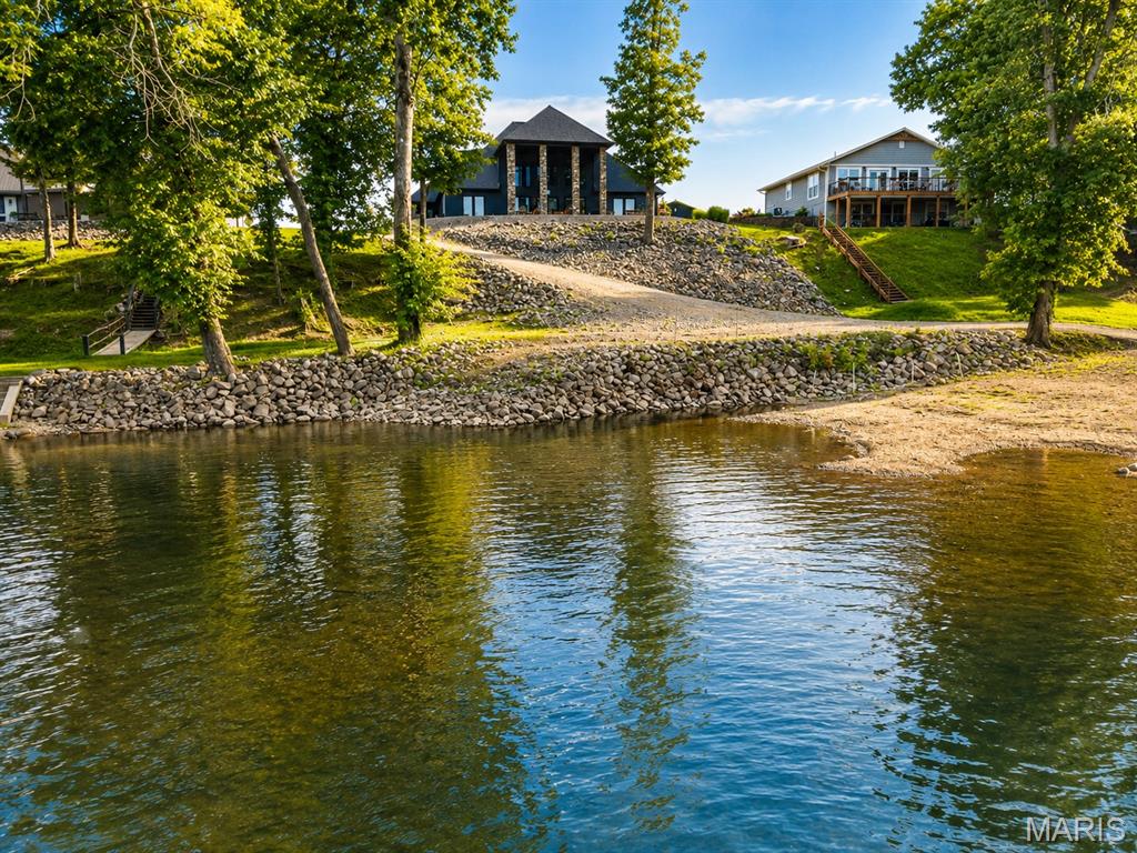 Welcome to your FULLY FURNISHED, private riverfront paradise on the beautiful Current River. This exceptional property sits on approximately 30 acres m/l and offers some of the most desirable river frontage in the region, featuring an easy, shallow walk-in river entry with little to no current, making it perfect for swimming, kayaking, fishing, and relaxing along the water’s edge.
The custom home is thoughtfully designed to blend comfort, character, and scenic beauty. Inside, you are greeted by hardwood floors, plantation-style shutters, and a flowing open layout that highlights the surrounding natural setting. The living room is a true showpiece, featuring 23-foot vaulted ceilings with rustic beams and a stunning 22-foot stone gas fireplace, creating an unforgettable focal point and a warm, lodge-style atmosphere ideal for entertaining or quiet evenings at home.
The dining room and kitchen are perfectly positioned for both functionality and style. The kitchen offers plantation shutters, an electric stove, built-in microwave, dishwasher, refrigerator, vent hood, backsplash, and generous workspace all opening to the main living areas. The dining room provides ample space for family gatherings and entertaining.
The main-level master suite is designed for privacy and comfort, offering carpeted flooring, a walk-out door to the patio, and peaceful views of the property. The attached master bathroom includes double vanity sinks, tile flooring, a very large walk-in tile shower, custom cabinetry, and a spacious walk-in closet.
Additional main-level features include a foyer with hardwood floors and plantation shutters, a guest bedroom with matching finishes, and a laundry room with tile flooring.
Upstairs, you will find a carpeted bonus room perfect for an office, media room, or additional living space, along with two upstairs bedrooms featuring an attached full bathroom, plus a separate hall full bathroom.
Outside is where this property truly becomes one of a kind. The land offers privacy, space to roam, and breathtaking river views. Whether you’re enjoying the river, watching wildlife, or hosting friends and family, this property delivers a true Missouri outdoor lifestyle.
A major highlight is the 70 x 36 three-car Morton building, which is far more than just a garage. This impressive structure includes a kitchen and bathrooms, making it ideal for guest quarters, entertaining, workshop space, or additional recreational use. It is perfect for river days, large gatherings, or housing boats, vehicles, and equipment. There is also a camper hookup behind the shop.
This property offers a rare combination of:
 • Current River frontage with easy walk-in access
 • Approximately 30 acres of land
 • Custom home with vaulted ceilings and stone fireplace
 • Main-level living with master suite
 • Multiple living and bonus spaces
 • 70x36 Morton garage with kitchen and bathrooms
 • Privacy, space, and unmatched natural beauty
Whether you’re looking for a full-time residence, vacation home, family retreat, or investment in one of Missouri’s most desirable river locations, this property delivers on every level.
Riverfront properties like this on the Current River are extremely rare and opportunities like this do not come often.
Schedule your private showing today and experience this incredible Current River retreat for yourself.