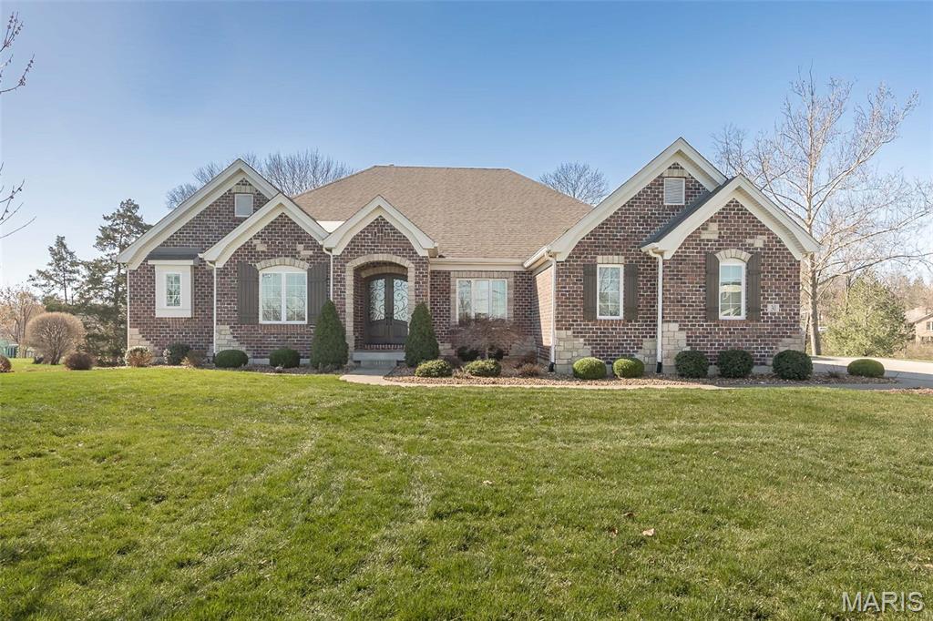Welcome to this exceptional ranch-style home in the award-winning Rockwood School District. A decorative front door opens to sweeping, light-filled living spaces with gleaming hardwood floors. Entertain in the formal dining room or gather in the great room, complete with built-in bookcases, a gas fireplace, and TV wiring above the mantel. The gourmet kitchen boasts custom cabinetry, a huge center island, upgraded stainless appliances, and a wet bar with sink and beverage fridge — adjacent to a breakfast room and a vaulted, beamed hearth room with a second gas fireplace and walkout to a deck with an outdoor fireplace. The main-level office features French doors and serene backyard views, while a convenient powder room serves guests. The primary suite is a tranquil retreat with hardwood floors, an expansive closet, and a luxurious bath with a soaking tub, oversized walk-in shower, and dual vanities. Two additional bedrooms share a full bath, and a spacious mudroom off the garage leads to the main-level laundry; the 3 car garage includes two electric-vehicle chargers. The walkout lower level walks out to a hot tub. The lower leval offers tall ceilings, a rec area with a  bar, a bedroom and full bath, plus a large unfinished area for storage or future expansion.