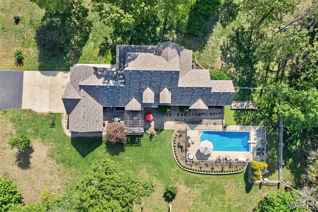 This stunning, country estate sits on 5 beautiful acres with panoramic views for days. The massive home features over 6,400 finished square feet, 10’ ceilings, geothermal heating & cooling, 6 bedrooms (4 with walk-in closets & private baths), and 5 full & 2 half baths. Beautifully refinished hardwoods, gas fireplace, sunroom & built-ins are extras you’ll love. The kitchen reno includes stunning granite countertops, glass tile backsplash, pot filler, sleek new appliances, & walk-in pantry. The master suite checks ALL the boxes, including double sinks, soaker tub, and 2 massive walk-ins with luxury organizing systems. The spacious upper level offers 3 bedrooms, 2 full baths, and walk-in attic storage. The finished basement allows you to entertain a crowd, including a wet bar, guest bedroom, bath, and ample storage. The back patio is where the real magic happens, featuring a well-equipped outdoor kitchen, a pergola, and a heated in-ground pool with a 9’ deep end and an auto safety cover. A 3-car garage with separate workshop space & a full bath completes the home. A brand-new roof, Anderson windows, an invisible pet fence, an in-ground sprinkler system, & a deluxe security system are bonuses you’re sure to value! This layout would work very well for multi-generational living as well. THIS is luxury living in a rural setting; the kind of DREAM HOME you don’t often find. Schedule your private viewing today. Be sure to check out the virtual tour included in this listing!