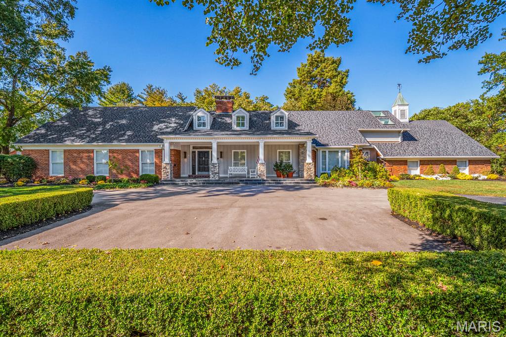 Nestled on a picturesque, tree-lined lane in the prestigious Kings Glen neighborhood sits this stunning one and half story Cape-Cod style estate. From the moment you arrive...the circle drive, welcoming front porch, and stately curb appeal sets the tone of what awaits inside.  This special home offers timeless elegance, exceptional craftsmanship and spectacular interior and exterior entertaining. Enjoy over an acre of gorgeous landscaping, gardens, heated saltwater pool & spa, fire pit, and multiple covered patios. Designed with sophistication and high-end finishes throughout, this home boasts almost 8,000 sq. ft. of luxury living. Step inside and get ready to be wowed!  The light-filled entry flows perfectly into the living and dining rooms featuring a glass fireplace, gleaming hardwood floors, exquisite molding and refined architectural details. The gourmet kitchen opens to the breakfast and hearth/family room with a stunning stone fireplace, wet bar and beamed ceilings.  Walk-out to the covered patio and your backyard oasis. Great space and floorplan for captivating gatherings. The spacious main floor primary suite has cove ceilings, a huge custom walk-in closet and the most beautiful marble bathroom of your dreams.  The primary wing also has an office/study with box beam ceilings and spectacular painted woodwork.  The main floor laundry room, and two powder rooms complete the first floor.  Upstairs you find 3 bedrooms (including an additional primary suite), breathtaking bath and deck overlooking the magnificent grounds. You will also love the lounge/sitting room (with a stunning bar) perfect for cozy gatherings. The lower level is amazing and includes a 5,000 bottle wine cellar, designed for the true connoisseur, with custom redwood and mahogany shelving and ambient LED lighting that highlights each vintage. Every detail -from the temperature regulation to the handcrafted display racks-reflect timeless luxury and impeccable taste. You'll also enjoy the spacious family room, enormous office/work out room, 5th bedroom (being used as a music room), full updated bath and plenty of storage. This move-in ready home is in sought after Town & Country within walking distance to parks, restaurants, and Straubs. Top rated Parkway West schools, Mason Ridge Elementary and close to many privates. This one is special so make your appointments today.