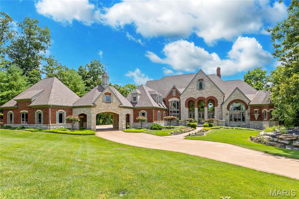 This architecturally significant estate from Schaeffer Homes features superb craftsmanship & exquisite interior detailing throughout. 22’ Marble foyer highlighted by floating staircase leads to elegant dining room & 2-sty great room with extensive millwork & elaborate fireplace. Designer kitchen featuring glazed cabinetry, commercial grade appliances & 11’ center island adjoins coffered breakfast room & vaulted hearth room with fireplace & French doors to sunroom. Barrel-vaulted primary bedroom suite with marble fireplace, sitting room & beautifully appointed bath offers an appealing retreat. The 2nd floor extends the living quarters with 3 additional bedrooms, 1 w/ensuite bath & 2 with Jack n’ Jill bath, laundry & bonus room. Walk-out Lower Level inspired by Big Cedar Lodge includes recreation room, game room, gathering bar, office, 5th & 6th bedrooms with Jack n’ Jill bath & pool bath. Wooded 3.4-ac lot with pool, deck & patio plus stocked pond, two 3-car garages & porte cochere. Additional Rooms: Mud Room