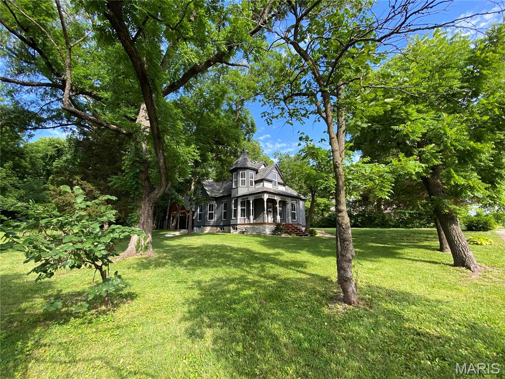 Ignore days on Market! Went under contract on 4-8. Back on Market-No fault of Seller! Beautiful renovated Victorian Home on .58 acres! Original woodwork, large sliding doors, main doors and so much charm! Renovation includes all NEW: Roof, exterior paint, front porch deck, carport/covered entertaining area with new concrete and back side walk, windows, kitchen with quartz countertops and soft close cabinetry, luxury vinyl plank flooring on main level, carpet upstairs, new bath flooring upstairs, interior paint, bathroom vanities and toilets, light fixtures and outlets/switches, plumbing, zoned HVAC, and so much more! The main level has foyer, hearth/dining room with vent free gas fireplace and original fireplace tile and wood surround with mirror, great room, kitchen, laundry and two bedrooms, one with a wardrobe, including Primary Bedroom and walk in closet with access to primary bath with original cast iron tub and dual vanities! The kitchen has access to the Primary bath for guest use. Quartz countertops and stainless appliances, farm sink, and a coffee bar! The upper level is a fairy tale dream! Can be used many different ways. Two sleeping rooms with gables or use the main upper area as a large bedroom with a bath! Beautiful turret area is great for a sitting area! Let your imagination run wild! Basement has new interior drain tile and sump pump/pit with walk out access. There is a shed just beyond the new covered patio/carport that is great as a utility shed. Beautiful property! Schedule your showing!