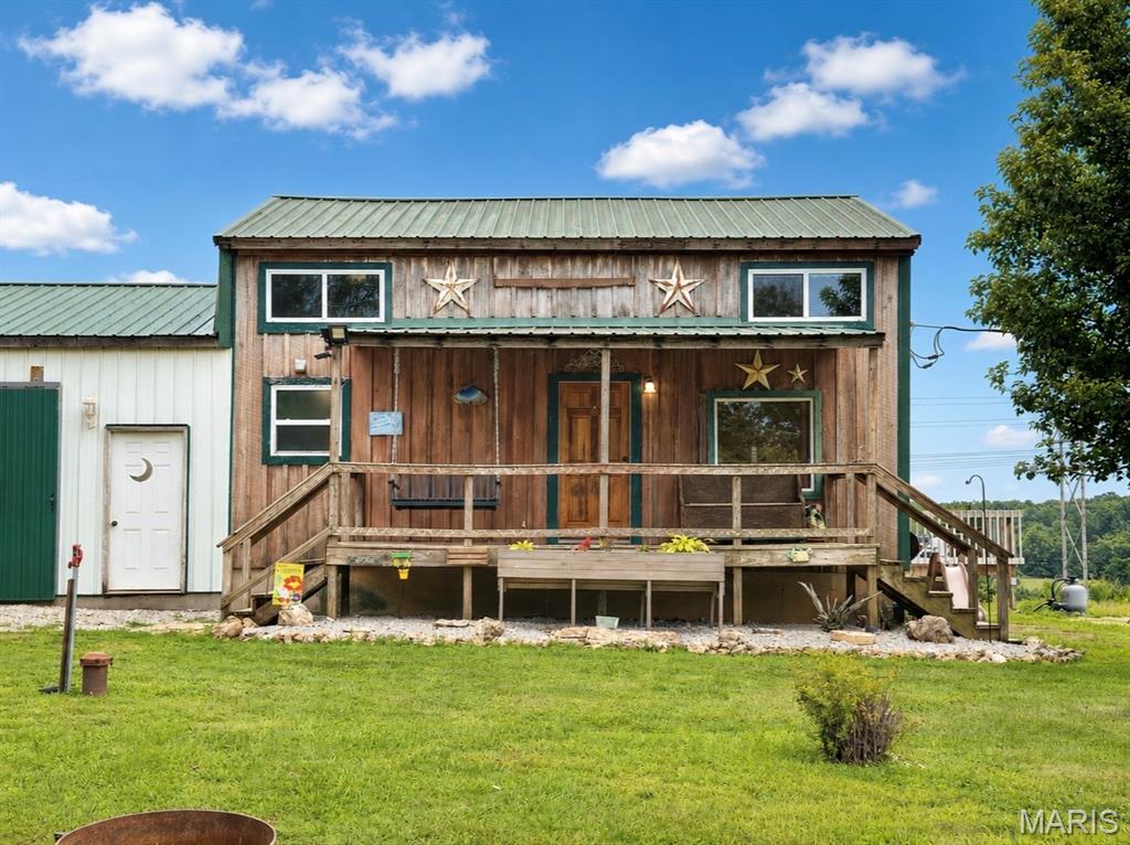 Escape to the peace and quiet of country living with this charming home situated on 4.13 acres. The property features a fully stocked pond with catfish, bass, crappie and bluegill along with multiple outbuildings, storage sheds, an attached 24’ x 36’ workshop, and a lean-to for additional covered storage.

Inside, the main level offers a spacious living room, kitchen and dining area, one bedroom, and a full bathroom. Upstairs you’ll find a second bedroom along with an office featuring a convenient half bath. The partially finished basement provides a large den area, a 9’ x 20’ bonus room, and a full bathroom with a combined laundry area, offering flexibility to fit your needs.

Enjoy the outdoors from the covered front porch or the screened-in back porch overlooking the property. The acreage also includes a chicken coop, blackberry patch, fruit trees, and plenty of open yard space, making it well suited for gardening, hobby farming, or simply enjoying the outdoors. If you’re looking for a peaceful rural property with room to spread out, this one is ready to welcome you home!