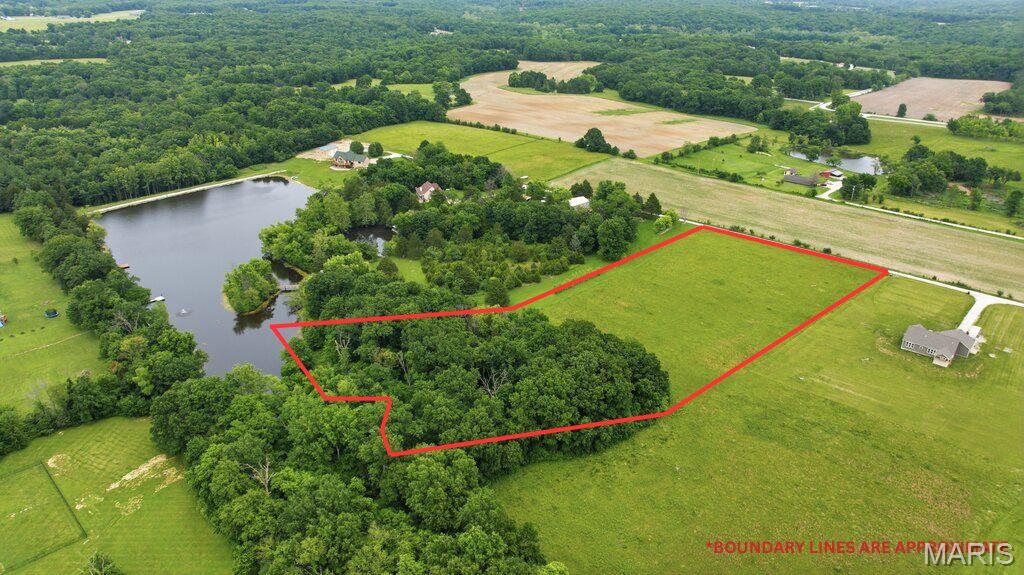 5.3 acres on shared lake!  Build your dream home on this beautiful 5.3-acre homesite featuring access to a shared lake, mature trees, and plenty of space to create your ideal country retreat. The property is ready for construction with electric already on site, saving you time and expense as you plan your future home. Enjoy the perfect blend of privacy and convenience, located just 10 minutes from Interstate 70 and ideally situated between St. Louis and Columbia. Whether you're looking for a peaceful weekend getaway or a full-time residence, this property offers the setting you've been searching for. Spend your days enjoying the lake with fishing, kayaking, canoeing, paddleboarding, wildlife watching, or simply relaxing by the water and taking in the scenic views.  Bring your builder, your plans, and your vision—opportunities like this don't come along often. Experience lake living, natural beauty, recreational opportunities, and easy access to city amenities, all on one exceptional property.