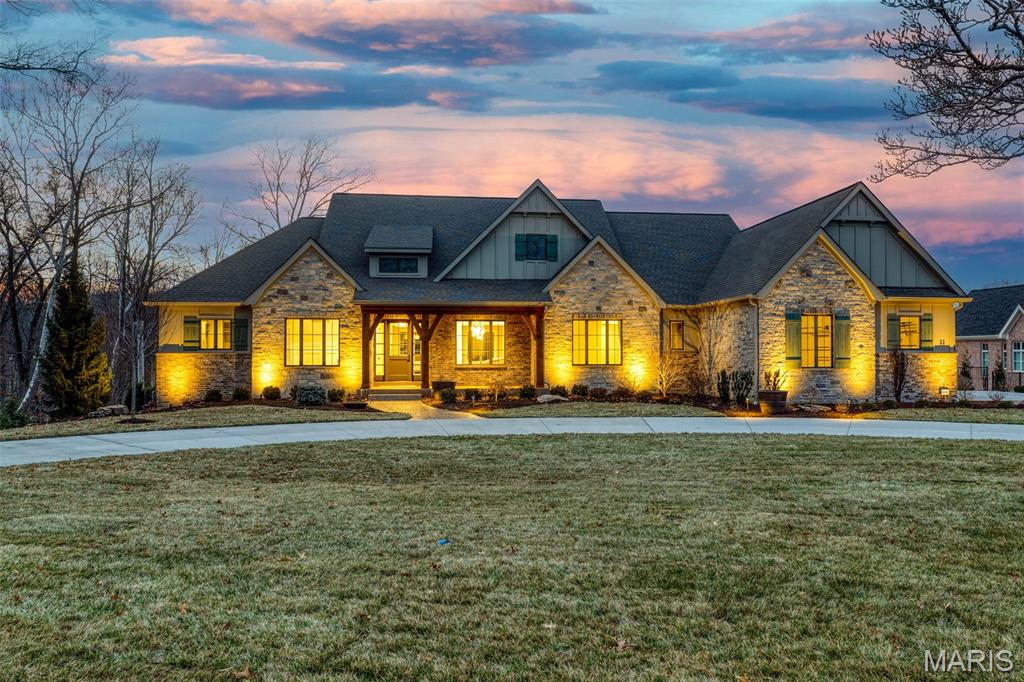 Introducing the Nottingham II Ranch at Ballas Ridge by Kemp Signature Homes. Offering over 3,700 sq. ft. on the main level, this French country–inspired estate blends timeless architecture with modern luxury. Exterior highlights include brick-and-stone masonry, cedar beams and trusses, classic wood shutters, and a 3-car garage. Inside, soaring vaulted, coffered, and beamed ceilings complement wide-plank flooring, custom millwork, and 8' solid-core doors throughout. The gourmet kitchen is outfitted with premium Dacor appliances and Kohler fixtures, while smart home technology enhances everyday living. Walls of Pella windows fill the open plan with natural light, and the main-floor owner’s retreat features a spa-like bath with free-standing tub and oversized shower. Outdoor living is redefined with a covered veranda overlooking a yard sized for a pool. Optional finished lower level available. Set within Ballas Ridge—Des Peres’ rarest new enclave of just four estate lots (1.59–6.5 acres)—this residence offers unmatched privacy amid rolling terrain, mature trees, and a pond. Enjoy a custom-built lifestyle just minutes from top schools, fine dining, boutique shopping, hospitals, and major highways.