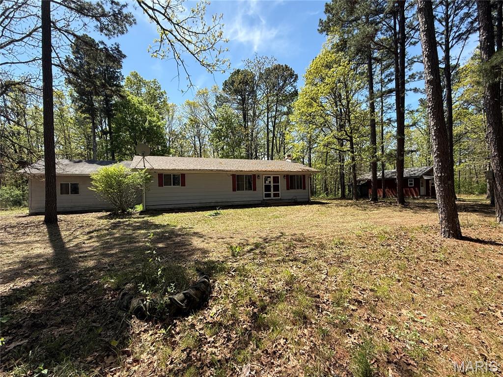 Ranch-style home situated on approximately 3+ acres with mature trees and a private setting. The home features a living room with a brick wood-burning fireplace and an adjoining kitchen and dining area with a center island and breakfast bar. A separate laundry room offers additional storage space.

The property includes three bedrooms (one non-conforming bedroom without a window), including a primary bedroom with an attached bathroom featuring a stand-up shower. An additional full bathroom and a sunroom provide extra living space. Sliding glass doors from the sunroom lead to a rear deck overlooking the acreage.

The detached shed can be used for storage, workshop space, or hobbies. With acreage, mature trees, and room for improvement, this property offers potential for buyers looking to invest in a fixer-upper.