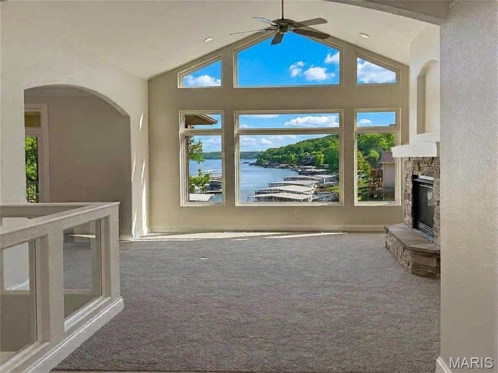Lakefront living in a peaceful cove at the 26mm! Breathtaking views! Fresh paint & new carpet - Move-in Ready! This waterfront retreat offers quick boat access to Lake of the Ozarks' favorite waterfront attraction: Margaritaville, Land Shark +more. Multiple outdoor living spaces maximize the lake views & outdoor entertainment. Complete w/ 12x30 dock, boat lift, Monark Seville 24' pontoon w/150HP Yamaha outboard, private boat ramp, paved roads - NO gravel, HOA-covered water/sewer, LEVEL parking for 4+ vehicles + attached garage. Open-concept floor plan features stunning hearth room w/ soaring cathedral ceilings, gas fireplace, & dramatic windows showcasing the lake. Chef's kitchen offers stainless steel appliances & sunny breakfast nook that opens to large screened porch overlooking the water. Main-level primary suite features coffered ceilings, a spacious walk-in closet, spa-inspired bath w/ double vanities, jetted tub, walk-in shower & private deck access. Walk-out lower level offers high ceilings & windows galore w/ spacious lakeside family room + 3 add'l bedrooms including 2nd primary suite w/ full bath + oversized walk-in closet. This large lot is at the head of the cove and offers 9ft of water during full pool. Bring your suitcase & enjoy life! Don't wait!!!