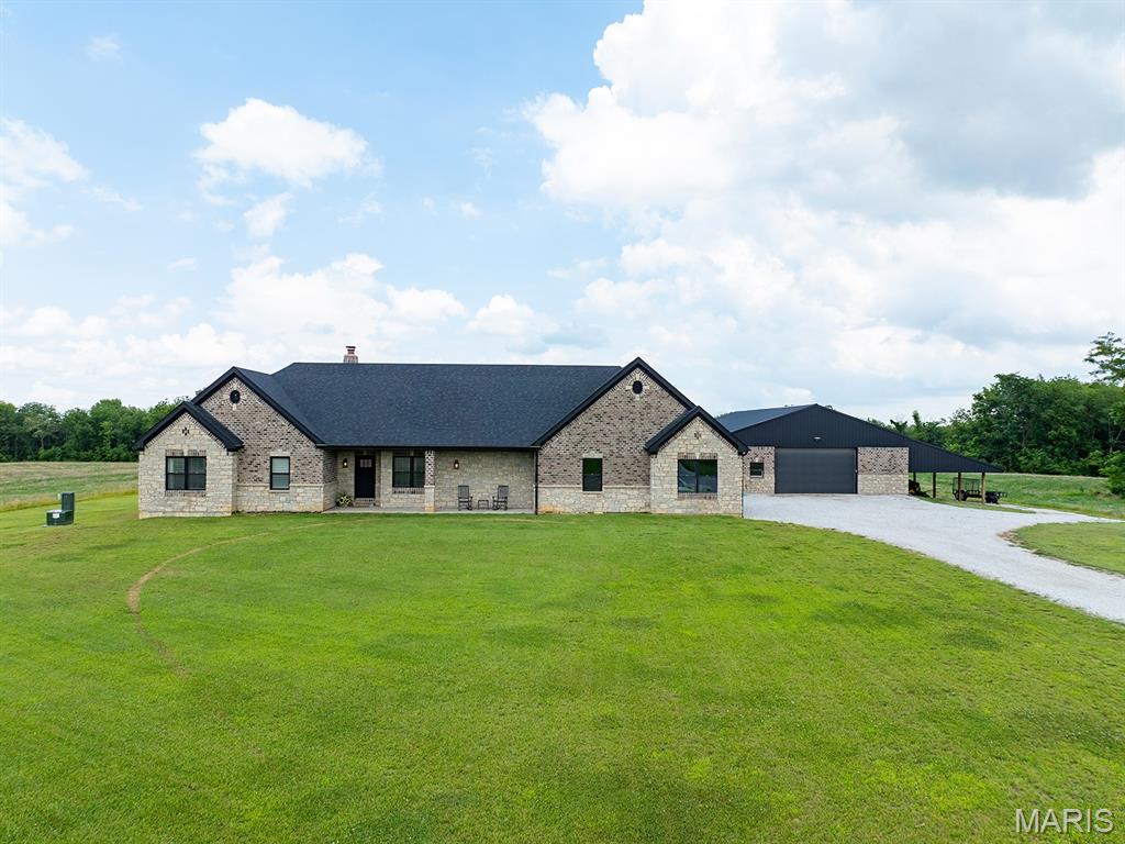 Rare opportunity to own a custom-built modern home on 45 acres just minutes from Mark Twain Lake, complete with creek frontage, productive farmland, valuable timber, and a 40x60 machine shop. This exceptional full masonry home backs to Lick Creek that flows to the lake, offering privacy, natural beauty, and abundant outdoor recreation.

The open-concept main floor features vaulted ceilings, 9-foot ceilings, Andersen windows, numerous builder upgrades, upgraded hard surface flooring, and abundant natural light. The chef’s kitchen boasts custom cabinetry, quartz countertops, upgraded stainless steel appliances, and a large center island, which is perfect for entertaining or family gatherings. The spacious primary suite provides a peaceful retreat with a full bathroom featuring multiple builder upgrades. The home also includes two additional bedrooms, an office, and a sportsman’s closet. With 2.5 baths and a massive 4-car garage, the home offers both comfort and functionality.

Outdoor living includes a cozy patio and a large covered patio connected to a 40x60 partial masonry machine shop. This impressive shop is ideal for equipment storage, hobbies, or a home-based business. The full basement adds efficiency and versatility with an energy-efficient HVAC system and a bonus forced-air wood furnace.

The property itself is equally impressive. The 45 acres include productive farmland that offers potential income by renting to local farmers, along with a mature grove of valuable walnut trees and additional white oak timber. These highly sought-after hardwoods enhance the beauty of the landscape while also representing a valuable natural timber asset. Whether you are looking for a private country estate, hobby farm, hunting retreat, or weekend getaway, this versatile property offers space, quality construction, natural beauty, and long-term value near Mark Twain Lake.