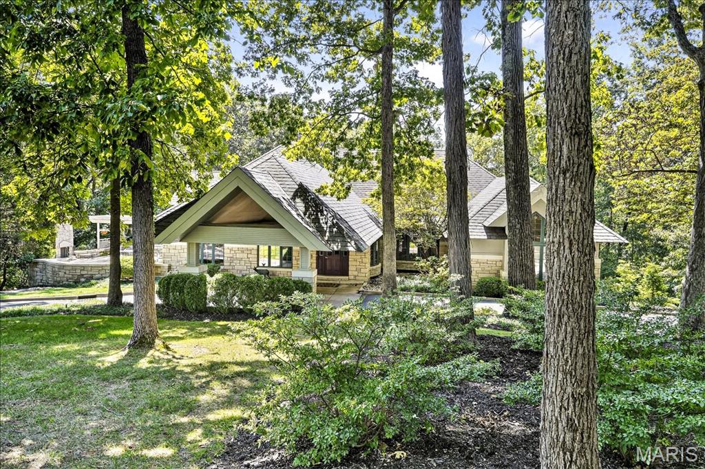 An extraordinary Frank Lloyd Wright-inspired 7,000 sq ft custom estate set on 3+ private, level acres in sought-after Pacland Place, where architecture and nature exist in perfect harmony. The outdoor living is nothing short of exceptional, featuring an in-ground pool with a tranquil waterfall, a covered patio, a fenced yard, and an additional side retreat complete with an outdoor fireplace, pergola, and hot tub—designed for both relaxation and unforgettable entertaining. A grand entry foyer welcomes you with a custom ceiling, bow window, and an impressive wine room, setting the tone for the home’s refined design. The massive great room showcases a stone-surround wood-burning fireplace, custom vaulted ceiling, walk-up wet bar, and French doors leading to the patio, seamlessly connecting to the formal vaulted dining room. Both spaces are highlighted by walls of custom windows that frame the surrounding landscape and fill the home with natural light. A private study with French doors and built-ins offers a quiet retreat. The spectacular kitchen is a true showpiece, appointed with solid surface countertops, extensive millwork, 42-inch cherry cabinetry, center island, double ovens, gas cooktop, dual sinks, access to the deck, and an adjoining breakfast room. The spacious primary suite is a sanctuary of its own, featuring a custom ceiling, a wall of windows, and a walk-in closet with French doors. The luxurious ensuite includes a steam shower, window seat, custom shower with dual shower heads, rough-in for a soaking tub, and double vanities. Two additional bedrooms and 1.5 baths complete the main level. The expansive walk-out lower level is an entertainer’s dream, offering a large family room with a wood-burning fireplace, a one-of-a-kind sunken walk-behind full wet bar, an office or potential bedroom, an additional bedroom, and two full baths. Additional highlights include two laundry areas (main and lower levels), a 3-car side-entry garage with a safe room, circular driveway, zoned HVAC, and countless custom details throughout. A truly remarkable residence that celebrates distinctive design, architectural character, and one-of-a-kind craftsmanship.
