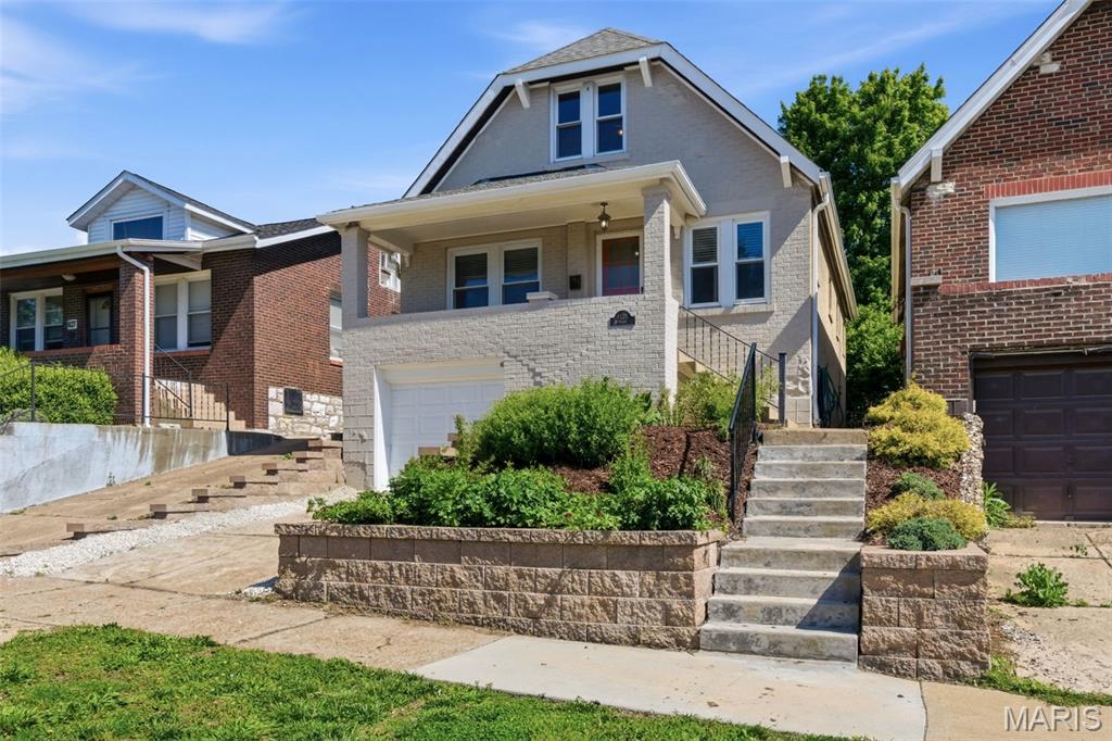 Charming vintage brick bungalow in the heart of sought-after Tower Grove South, blending timeless architectural character with thoughtful modern updates. Perched above the street with a welcoming covered front porch, this beautifully maintained home offers warmth, charm, and flexible living space in one of St. Louis’ most vibrant neighborhoods. Inside, classic details including stained glass windows, refinished hardwood floors, crown molding, archways, and French doors create a distinctive and inviting atmosphere throughout. The spacious living and dining areas flow naturally into the beautifully updated kitchen, fully remodeled in 2023 with modern finishes and improved functionality. The home offers two generously sized bedrooms, including an expanded primary bedroom with the addition of a closet for enhanced storage and usability. The retro-inspired bathroom adds personality and charm while complementing the home’s historic appeal. The lower level provides excellent flexibility with open recreation space, laundry area, multiple storage rooms, and direct access to the backyard. Outside, the fenced rear yard creates a true city oasis with mature landscaping, garden beds, and a newer patio perfect for relaxing, entertaining, or enjoying evenings around a firepit. Additional updates include a newer furnace and central air system, updated retaining wall, vinyl tilt-in windows, and thoughtful improvements throughout. Off-street parking via driveway adds everyday convenience with additional parking pad at the rear alley. Located just moments from Tower Grove Park, local restaurants, coffee shops, and neighborhood favorites, this move-in ready home offers the perfect combination of historic charm, updated living, and exceptional location.