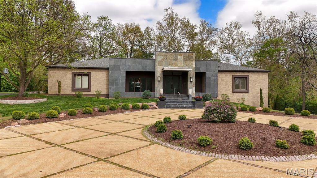 Architecturally striking contemporary home by Arthur Sitzwohl, crafted for effortless luxury living. Expansive walls of glass flood the home with natural light and create a seamless connection to the slate patio and saltwater pool. Thoughtfully curated with art lighting and gallery-like spaces to showcase a prized collection, every detail elevates the everyday. A sunken living room with a gas fireplace and an elegant dining area with custom built-ins and striking Neolith surfaces set the tone for sophisticated entertaining. The chef’s kitchen features Brazilian quartzite countertops, Wolf and Sub-Zero appliances, and white oak flooring throughout much of the main level. The reimagined primary suite is a serene retreat with a sitting room or office, a stunning spa-inspired bath, a custom walk-in closet, and a private deck with a hot tub overlooking a tranquil waterfall. The east wing offers an en-suite bedroom, two additional bedrooms, and a full bath. Renovated in 2023, the walk-out lower level includes built-ins, a full bath, and generous storage, opening directly to the backyard and pool—creating the ultimate setting for relaxation or entertaining. A rare opportunity to own a home in Ladue Schools where design, light, and lifestyle come together—an experience you won’t want to miss. Pool is now open!