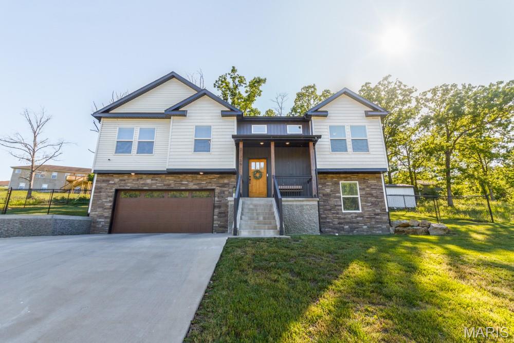 Absolutely stunning 5-bedroom home situated on two lots at the end of a quiet street just minutes from Fort Leonard Wood! Offering nearly 2,750 finished sq ft, this beautifully maintained and exceptionally well-cared-for split-foyer home blends luxurious design with a welcoming feel that makes you feel right at home.  Filled with an abundance of natural light, the home features luxury vinyl plank flooring throughout, soaring vaulted ceilings with exposed wood beams, arched entryways, and upscale finishes at every turn, while rooms without vaulted or tray ceilings still offer spacious 9-foot ceilings.  The kitchen is of designer quality and showcases quartz countertops, a painted brick backsplash, stainless steel appliances, and a striking shiplap ceiling.  Just off the kitchen is a formal dining room accented with wainscoting on the walls and a farmhouse-style light fixture.  The spacious primary suite features a coffered ceiling, spa-like bath with soaking tub, tiled walk-in shower, double vanity, and oversized closet. This is truly a space you can unwind in and relax.  The main floor also includes two additional spacious bedrooms connected by a Jack-and-Jill bathroom, plus a convenient half bath. The finished walkout basement offers an ideal second living space with a large family/recreation room, 2 additional bedrooms, and a full bath this space is perfect for entertaining or relaxing.  Outside, enjoy the black chain-link fenced backyard, concrete patio, storage shed, and spacious 2-car garage with additional front storage space. Situated on a combined half-acre lot with exceptional curb appeal, this move-in-ready home is truly one of a kind!