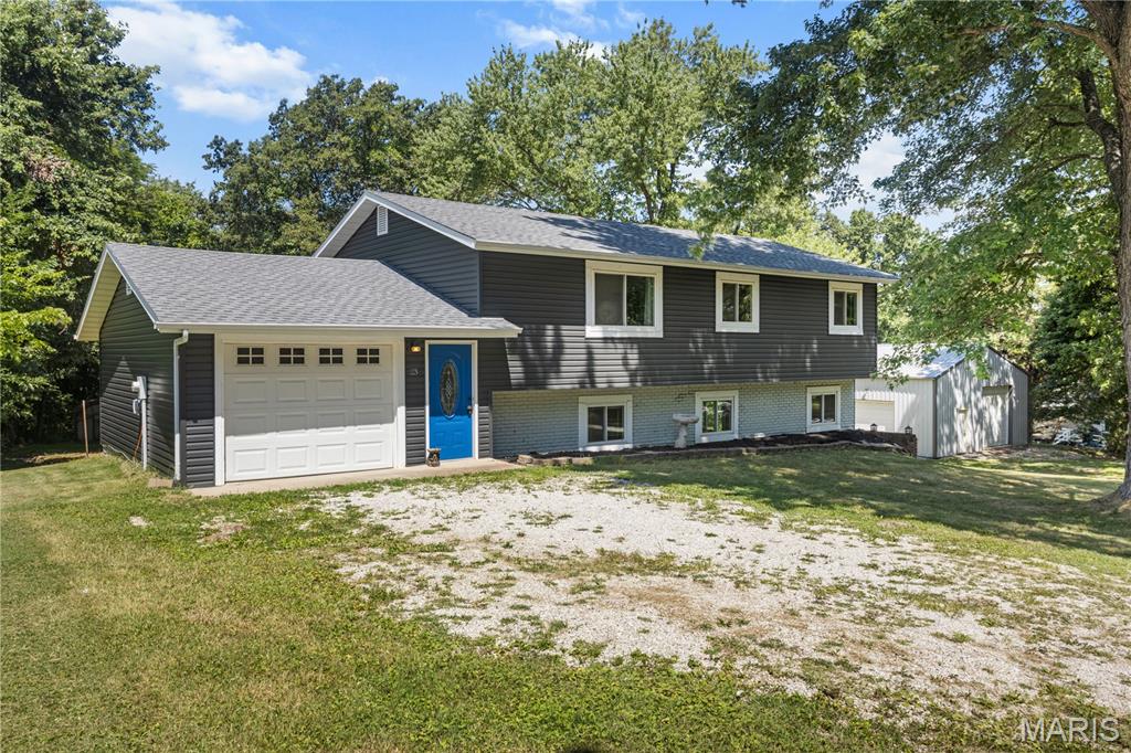 Enjoy the privacy of a large backyard that backs to peaceful woods while remaining conveniently close to shopping, dining, parks, schools, and major commuter routes. This spacious home offers a comfortable blend of updated living space, flexible indoor and outdoor areas, substantial storage, and a quiet setting that works well for everyday living, entertaining, hobbies, and recreation.

The interior offers generous room sizes, fresh paint, new flooring, and a practical layout with plenty of space to spread out. The lower-level family room creates a comfortable second living area that could be used as a movie room, game room, home office, workout area, playroom, or gathering space for family and friends. The flexible layout allows each area of the home to be used in a way that fits a variety of lifestyles and changing needs.

Many of the major systems and features have been updated during the past several years, including the roof, gutters, windows, numerous interior and exterior doors, flooring, water heater, HVAC system, septic system, kitchen cabinets, and selected light fixtures. These improvements give the next owner the benefit of many substantial projects already having been completed while still leaving opportunities to personalize the home and make it their own.

One of the property’s strongest features is the approximately 30-by-40-foot detached building with a full concrete floor. This oversized space is ideal for storing equipment, tools, lawn machinery, boats, ATVs, motorcycles, recreational vehicles, campers, and other toys. It also offers excellent potential for a workshop, hobby space, project area, or additional vehicle storage. Buyers looking for room beyond a standard garage will appreciate the versatility and value this building adds to the property.

The oversized attached garage provides additional space for vehicles, everyday storage, tools, lawn equipment, or household projects. With both the attached garage and detached building, the property offers an uncommon amount of usable storage and work space.

Outside, the expansive yard provides plenty of room for pets, gardening, outdoor games, gatherings, a firepit area, or simply relaxing while enjoying the wooded backdrop. The trees behind the home create a peaceful and private setting, offering the feeling of being away from it all without sacrificing convenient access to nearby communities and everyday services. The yard offers room to enjoy outdoor living without feeling crowded by neighboring properties.

The home’s combination of multiple living areas, generous storage, updated systems, and outdoor space makes it well suited for buyers who want more flexibility than a typical residential property provides. Whether the goal is to entertain, work from home, store equipment, enjoy hobbies, or simply have more room for daily life, this property offers a variety of possibilities.

Located near Highway 21 and Hayden Road, the home provides convenient access to Hillsboro, Festus, De Soto, and the greater St. Louis area. Local parks, restaurants, shopping, schools, and services are all within an easy drive, with Gravois Bluffs and other popular destinations also readily accessible.

With its extensive improvements, spacious interior, multiple living areas, exceptional storage, large private yard, and wooded setting, this property offers a rare combination of comfort, privacy, versatility, and convenience. It is an excellent opportunity for anyone looking for a home with room to live, work, relax, entertain, and enjoy the outdoors.