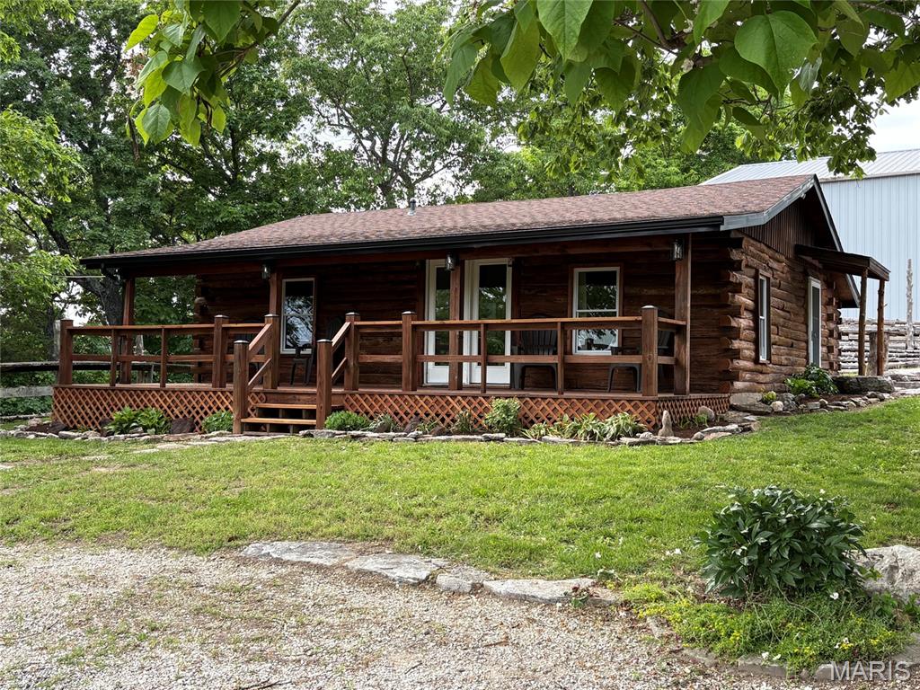 Cozy lakefront Log cabin at Pinnacle Lake. Whether it's the lake, the sunsets, or just watching the clouds roll in over the neighboring hillsides, the views from this property will leave you breathless. This home is loaded with features and updates that include, open floor plan, modified coffer ceiling with recessed lighting, newer fans and fixtures, updated kitchen boasting huge center island with tons of storage, and a remodeled bath. Outside you will find a newer architectural shingled roof, new black facia and gutters, freshly stained exterior, new lighting, decorative landscaping, raised garden area, and a full length covered porch overlooking the lake. We're not done yet, behind the home is a large, detached garage with two overhead doors. Inside you can let your imagination run wild with the large open area, closed off heated workshop, separate bay, and an upstairs with additional rooms started. The possibilities are endless! All this sitting on over 3 acres!