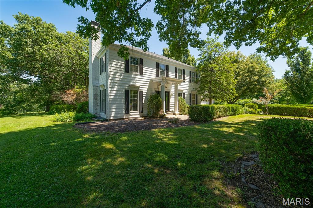 Nestled on over 3 private acres in sought-after Weldon Springs Heights, this grand two-story home offers space, charm, and timeless appeal. Hardwood floors extend throughout the main and upper levels, with the exception of one carpeted bedroom. The spacious floor plan features large rooms, built-in bookcases, and a welcoming family room perfect for gathering. The eat-in kitchen boasts a center island, updated appliances, and ample space for everyday living and entertaining. Retreat to the oversized primary suite with a private bath. Step outside to enjoy the large patio and peaceful, wooded setting. The oversized garage included a tandem bay, providing space for up to three vehicles. Additional updates include a brand-new Anderson front door. A rare opportunity to enjoy privacy, acreage, and a premier location all in one exceptional property.