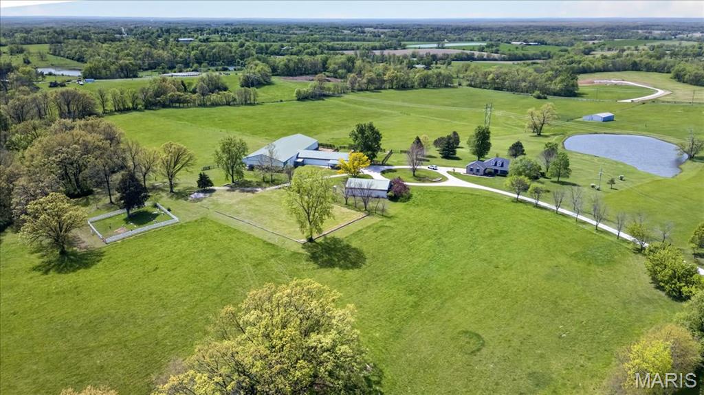 38-Acre Equestrian Estate | Elsberry, MO ~ Discover an extraordinary 38.11-acre equestrian sanctuary offering a perfect blend of luxury and utility. This premium estate features an exquisite 6-stall horse barn, a professional indoor arena, an outdoor arena, fenced pastures, and high-yield hay fields, complemented by a serene, stocked pond. At the heart of the property is a custom 3,266 sq. ft. ranch home with a 2-car garage. The open interior boasts a majestic 13’ vaulted living room with a brick fireplace, custom built-ins, and plantation shutters. Beyond its world-class equestrian features, the true value of this 38.11-acre estate lies in its future flexibility. The expansive, gently rolling terrain is perfectly suited for land division, offering a rare opportunity to design a private multigenerational estate with multiple family residences. 4.5 miles to Hwy 61. Schedule your tour today!