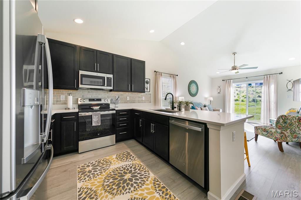 Enjoy modern living in this newer, well-appointed 2-bedroom, 2-bath home located in a peaceful community with easy access to the metropolitan area. The open floor plan is highlighted by a vaulted ceiling in the living room, creating a bright and spacious atmosphere, while additional windows and sliding glass doors flood the space with natural light. The kitchen features 42” soft-close cabinets and drawers, quartz countertops, and stainless-steel appliances. The primary bedroom offers a private en suite bath and walk-in closet, while a second bedroom and additional full bath provide added conveniences. Main-floor laundry includes the washer and dryer, which stay with the home. Unlike standard builder-grade models, this home has many upgrades including two-panel interior doors, Craftsman-style garage door, luxury vinyl plank flooring throughout, and integrated smart home technology with keypad entry and a smart thermostat. Additional value is found in the whole-house Watts Pure Water Softener installed in 2025 and a full basement with an egress window and full bathroom rough-in - massive potential for future living space. Nestled in a beautiful community with gentle hills perfect for both leisurely strolls and challenging runs, this move-in-ready home offers many aspects of a custom-build without the wait or the added expense.