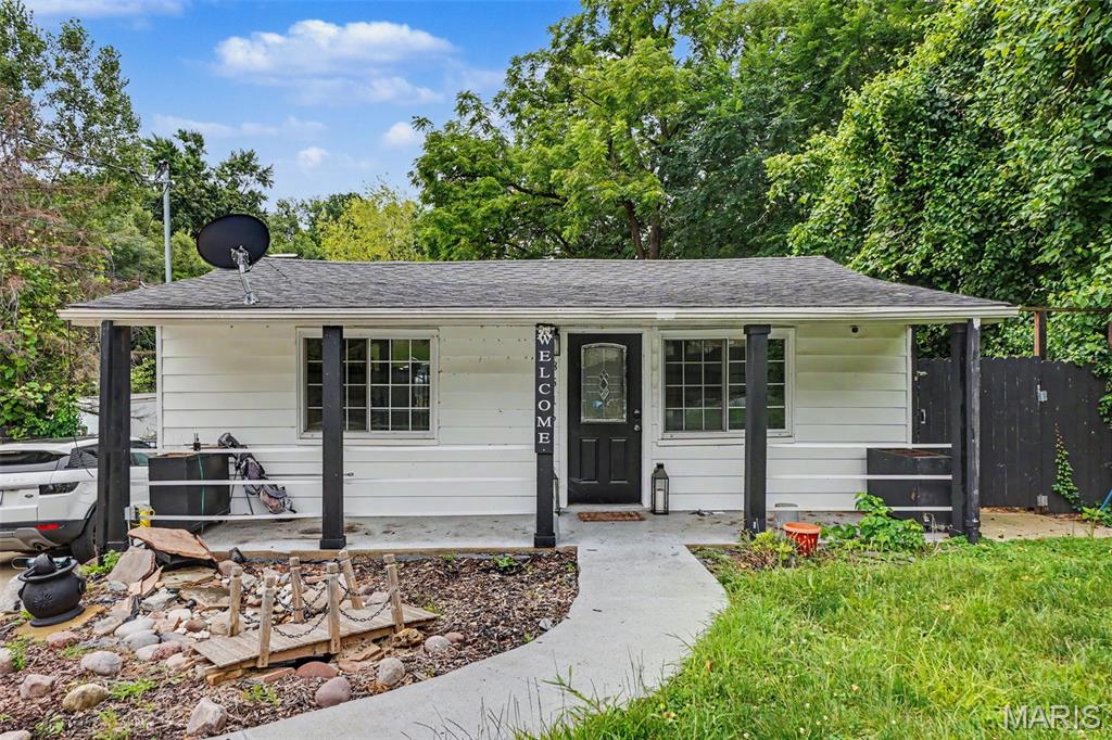 Summer Entertainment Happens Here! Property is privacy fenced and has front gate. Front has water feature in landscaping, covered front porch, and lots of parking spaces. Enter into living room with recessed lighting, LVP flooring throughout main level, and an arched doorway into dining room. Kitchen has black cabinets, black tile countertops & backsplash, stainless steel appliances, and fridge stays. Main bath has large vanity. Home has character with built in shelves. Some newer tilt in windows. Basement bathroom has penny hexagon floor tile and glass shower door. 2 other rooms in basement besides laundry area, one could be sleeping room, with walkout access to back. Backyard has pergola with lighting, jacuzzi (stays), lots of room, heating stands for when fall starts, shed, and chicken coop (Unincorporated, so they’re allowed.) So much value, for so little price. Make an appointment today!