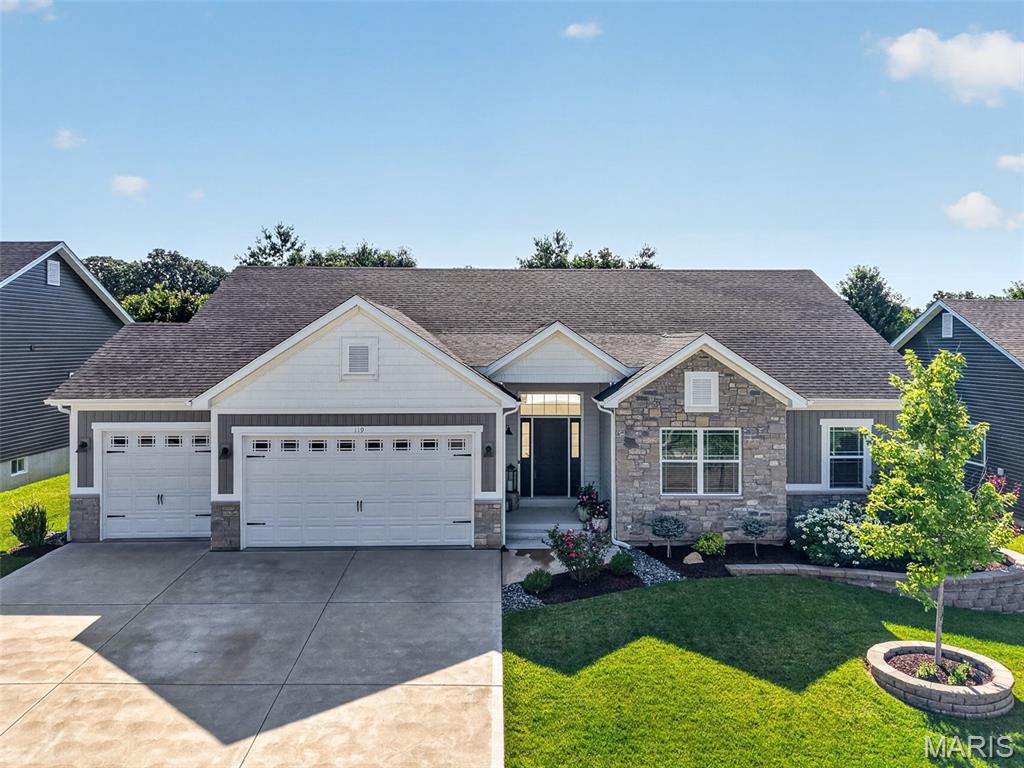 Prepare to be WOWED!  This amazing 4 bedroom, 3.5 bath home sits in a prime Wentzville location and shows like a model home. This home showcases fantastic, on-trend finishes, an oversized 3 car garage and a stunning covered patio on a lot backing to trees. The curb appeal is impressive with stone, board and batten siding, prairie style window grills, shake accent siding, carriage style garage doors, coach lights, architectural shingles (3 yrs old), lush landscape and lawn irrigation.  Features include luxury vinyl plank flooring, staggered height cabinets with crown, recessed lighting, island with seating bar, granite/quartz countertops, tile backsplash, soft close feature, walk in pantry with custom organizers, drawer micro, stainless steel appliances, double oven, chimney style range hood, butler pantry/beverage center, 9 ft ceilings throughout the main with dramatic 11 ft ceilings in the Great Room, crown molding, gas fireplace with plank surround and stone hearth, wrought spindles to the finished lower level, large Primary Suite, furniture quality double bowl vanity, jetted soaking tub, custom tile shower, semi-frameless shower doors, separate water closet, walk in closet with custom organizers, vinyl plank tile flooring in the bathrooms, spacious secondary bedrooms, 5 panel doors, main floor laundry with cabinetry, water softener, 50 gallon water heater, Ring doorbell and more. The finished lower level offers approx 835 sq ft with a Family/Rec Room, Office with double glass doors, Bedroom with egress, full bath with custom tile shower and more.  There is plenty of unfinished storage space and there are 3 egress windows in the lower level.  There is a stunning 18 x 17 covered patio with stone-based columns and cedar posts overlooking the fenced, tree-lined back yard. The garage is oversized (23.5 D), is insulated-drywalled-finished and has insulated garage doors.  Excellent location near shopping, restaurants, recreation, services and easy access to Hwys 70 and 40/61.  Incredible, a must see!