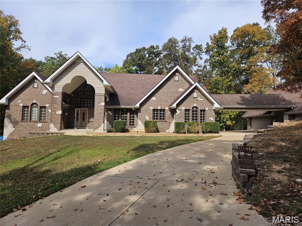 Escape to your own 3-acre sanctuary where custom craftsmanship and soaring spaces redefine the ranch-style retreat. This brick-and-stone estate with a brand new roof welcomes you with a stately portico and a thoughtful split-bedroom layout designed for ultimate privacy. The heart of the home is the breathtaking great room, where 22-foot vaulted ceilings and a cozy wood-burning stove create an atmosphere that is both awe-inspiring and inviting. The chef-inspired kitchen features rich wood cabinetry, granite countertops, and elegant tile floors, flowing seamlessly into a dining room adorned with a sophisticated coffered ceiling. Retreat to the primary suite, tucked away for serenity, while the additional main-floor bedrooms share a convenient Jack-and-Jill bathroom. The lower level is an entertainer’s dream, boasting 10-foot deep-pour ceilings, fresh paint, and brand-new carpeting. Here, you’ll find a wood bar with a natural edge top and a pellet-burning stove, the perfect spot for evening gatherings. Enjoy outdoor living on a composite deck overlooking your private oasis. With a massive 6-car garage, there is room for every hobby, vehicle, and storage need imaginable. Schedule a showing today!