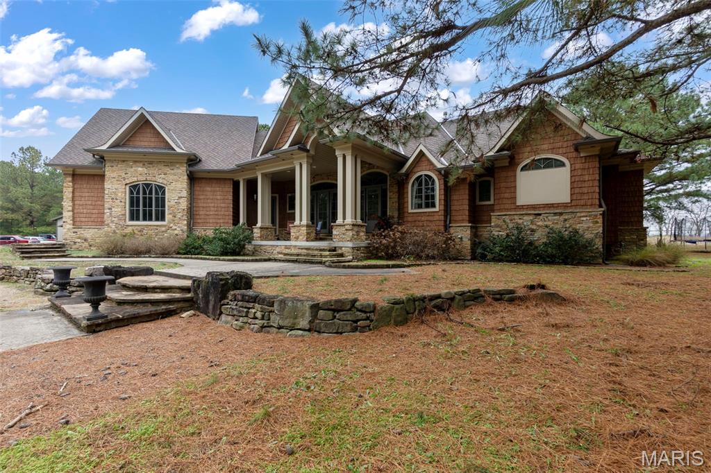Welcome to 1355 Ridgeway Circle in the highly desirable Pine Ridge Ranch subdivision—a one-of-a-kind estate on over 10 acres combining elegance, functionality, and comfort. This custom-built home offers 5 legal bedrooms plus 2 additional bedrooms in the basement (each with attached baths), for a total of 7+ sleeping spaces and 8 bathrooms (6 full, 2 half). Designed with both family living and entertaining in mind, this property is as versatile as it is stunning. UPDATE: Listings #26003286 and #26003284 can be packaged together with this sale for a total of just over 20 acres of included land!

From the moment you step through the front door, you’ll be greeted by soaring ceilings, an abundance of natural light, and spacious open living areas. The main level features a grand living room that flows seamlessly into the dining space and gourmet kitchen. The kitchen is a showstopper, complete with a massive refrigerator/freezer, double ovens, built-in dishwasher, walk-in pantry, oversized sink with a secondary prep sink, and custom cabinetry—all overlooking the private backyard. Just off the kitchen and dining area, you’ll find a screened-in porch with ceiling fan and lighting, ideal for fall evenings, weekend game days, or year-round entertaining.
The main-level primary suite offers true luxury, including a spa-like bathroom, large walk-in closet, and private access to the back patio and pool. A spacious office sits near the entryway and primary suite, making the perfect work-from-home space, nursery, or flex room. Two additional bedrooms on the main level share a convenient Jack-and-Jill bathroom. The laundry/mudroom is thoughtfully designed with cabinetry and a sink for everyday convenience.
Upstairs, you’ll discover a second living area along with two generously sized bedrooms, each with their own full bath. The finished basement provides yet another living space, highlighted by high ceilings, LED lighting, and a warm, inviting feel. Entertain with ease thanks to the second full kitchen, complete with a wine refrigeration system, bar seating, oven/range, built-in microwave, and custom cabinetry. Two additional rooms in the basement—each designed as bedrooms—feature private full bathrooms with tile showers, large tubs, and spacious vanities. A convenient half bath for guests, along with multiple utility and storage rooms, round out the basement level.
Step outside to enjoy your own private retreat. The backyard features an in-ground pool with diving board, automatic powered cover, and a pool house with a restroom, allowing guests to enjoy without needing to enter the home. The partially covered patio and expansive concrete pool deck provide plenty of space to relax and entertain while taking in views of the surrounding pine trees and wooded acreage.
Parking and storage are abundant with a circle drive, attached two-car garage, and a large shop with 10-foot overhead doors—perfect for projects, hobbies, or extra storage.
Located in Benton’s Pine Ridge Ranch subdivision, this home is just minutes from I-55, offering quick access to both Cape Girardeau (20 minutes north) and Sikeston (20 minutes south). Here, you’ll enjoy the perfect blend of country living with subdivision convenience, all in a peaceful and beautifully maintained setting. This property also includes a generator which allows for the house to stay fully running like normal during a power outage. 
If you are looking for a spacious, custom-built home with luxury features inside and out, plenty of room for family and guests, and a property designed to entertain year-round, this Southeast Missouri estate is truly one you do not want to miss!