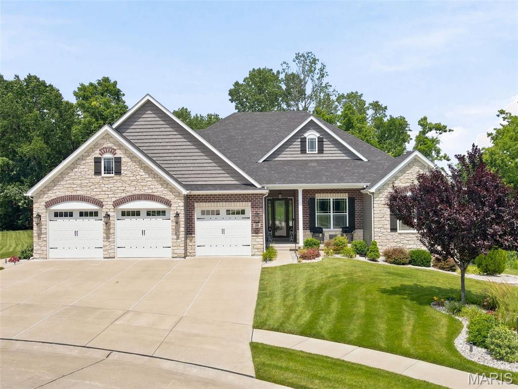 ONE OF A KIND CUSTOM 2021 LOMBARDO RANCH LOOKOUT W/SCREENED IN PATIO! Enjoy quiet mornings and serene evenings in your own tranquil, tree-lined oasis offering unparalleled privacy nestled in the back of the highly sought after Sandfort Farms subdivision! An ideal setting with 360 degree peaceful views of nature including subdivision pond w/fountain. Conveniently located near I-70, lets you be just 10 minutes from downtown St. Charles & 20 minutes to the airport! You'll find DESIGNER FINISHES throughout the nearly 4500 sq ft of living space which offers 5 bedrooms & 4.5 baths! Open concept floor plan featuring 11' ceilings in Great Rm, Breakfast Rm, Kitchen & Sunroom + 9' on the remaining 1st floor and lower level. Upgraded taller windows + transom toppers fill the main living areas with lots of natural lighting highlighting the rich ENGINEERED HARDWOOD FLOORING! 
STUNNING SIGNATURE LOMBARDO KITCHEN featuring ARCHED STONE surrounding professional series 5-burner gas cooktop and SS chimney hood accented with large subway tile backsplash in the herringbone pattern. Walk-in pantry and 42" soft close white cabinetry w/crown molding offer many pull outs for pots & pans, spice rack, full Lazy Susan & DBL trash cans. Above & below cabinetry lighting to brighten up your work area is an added plus! BEAUTIFUL QUARTZ COUNTERTOPS! Huge center island w/breakfast bar seating also houses upgraded SS drawer microwave. Custom wine bar area w/display cabinetry, wine storage & frig. Add the DBL wall ovens + DW and you have the perfect chef's kitchen for your family's enjoyment! Cozy up this winter next to the STONE FLOOR TO CEILING GAS FIREPLACE in the spacious Great Rm! Entertaining here is a breeze with the expanded Savannah floor plan adding a SUNROOM full of windows!
Double doors leads to spacious primary suite w/tray ceiling & DBL crn molding adjoins a spa-like retreat bathroom complete with shower featuring regular and rain shower head, designer tile, full view shower doors & upgraded black fixtures.
Separate soaking tub with tile accent surround. DBL undermount bowl vanity with quartz top + storage tower. Primary large walk-in closet connects to both bathroom AND easy pass thru laundry room w/pocket doors. 2 additional good sized bedrooms, both with walk-in closets plus home office accessed by French doors are serviced by 2nd full bath featuring sliding barn style shower doors. Powder rm + laundry room w/sink complete main level. The recently finished lower level adds tons of extra living space w/an enormous family room, 2nd owner's suite complete w/private upgraded bath & good sized walk-in closet, 5th bedroom/office & 4th full bath - so perfect for entertaining or extended family w/4 lookout windows + an egress window. Believe it or not there is still plenty of storage area! Home features Crown Molding & Recessed lighting throughout! Dual high energy efficient Lennox HVAC systems plus 50 gallon hot water heater with recirculator. Inground sprinkler system in both front & back yard. 8' white panel doors! Taller baseboards on both levels! Oversized 36x28 3-car HEATED GARAGE! Improved insulation with R 15 walls & R 40 ceilings! Lower level finished with sound proofing boards and stamped foundation walls to look like brick.  Dehumidifier with ultraviolet bacteria remover. 400 amp total electrical service. CAT 6 wiring!